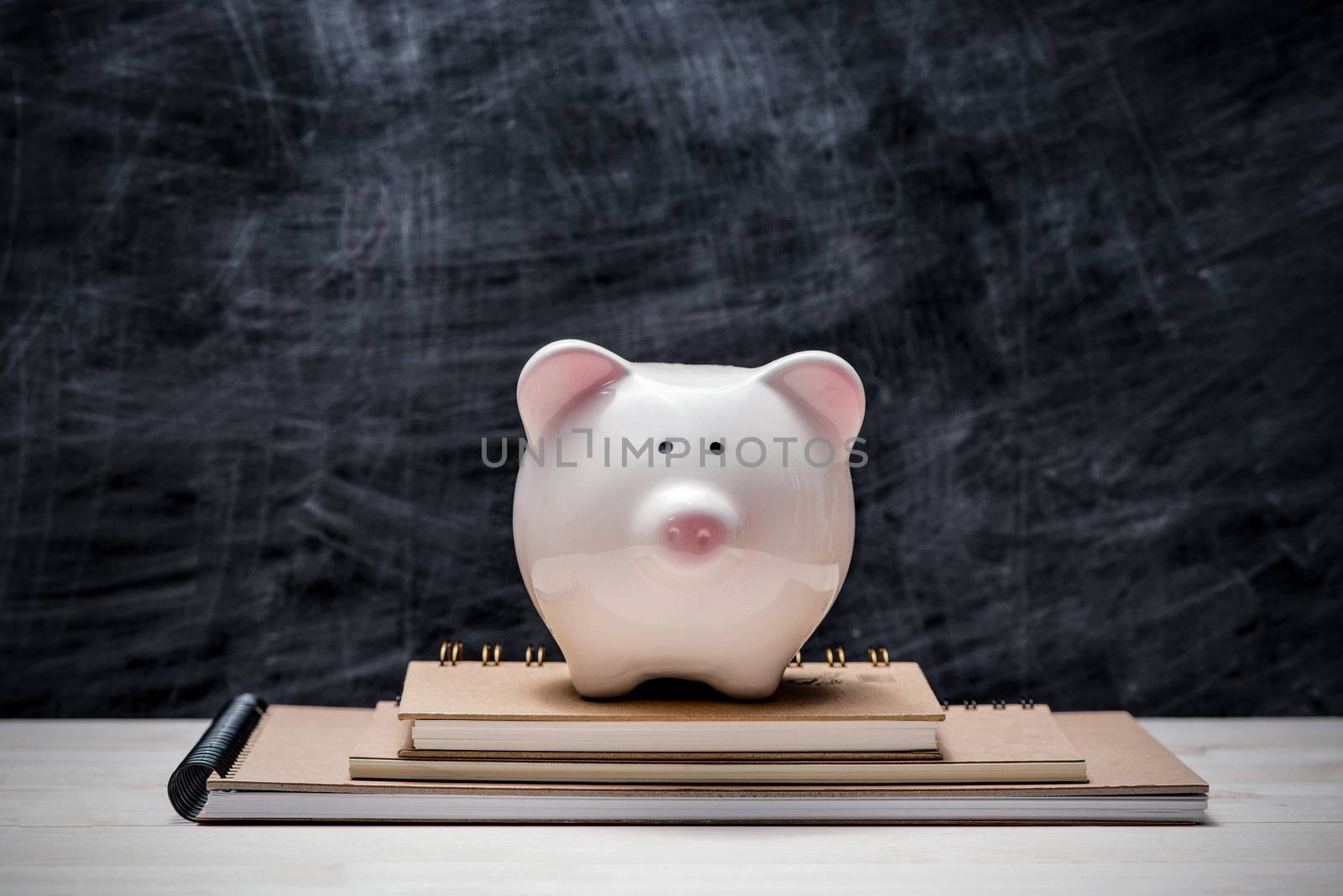Education financial saving. Pink Piggy bank on top of books with by makidotvn