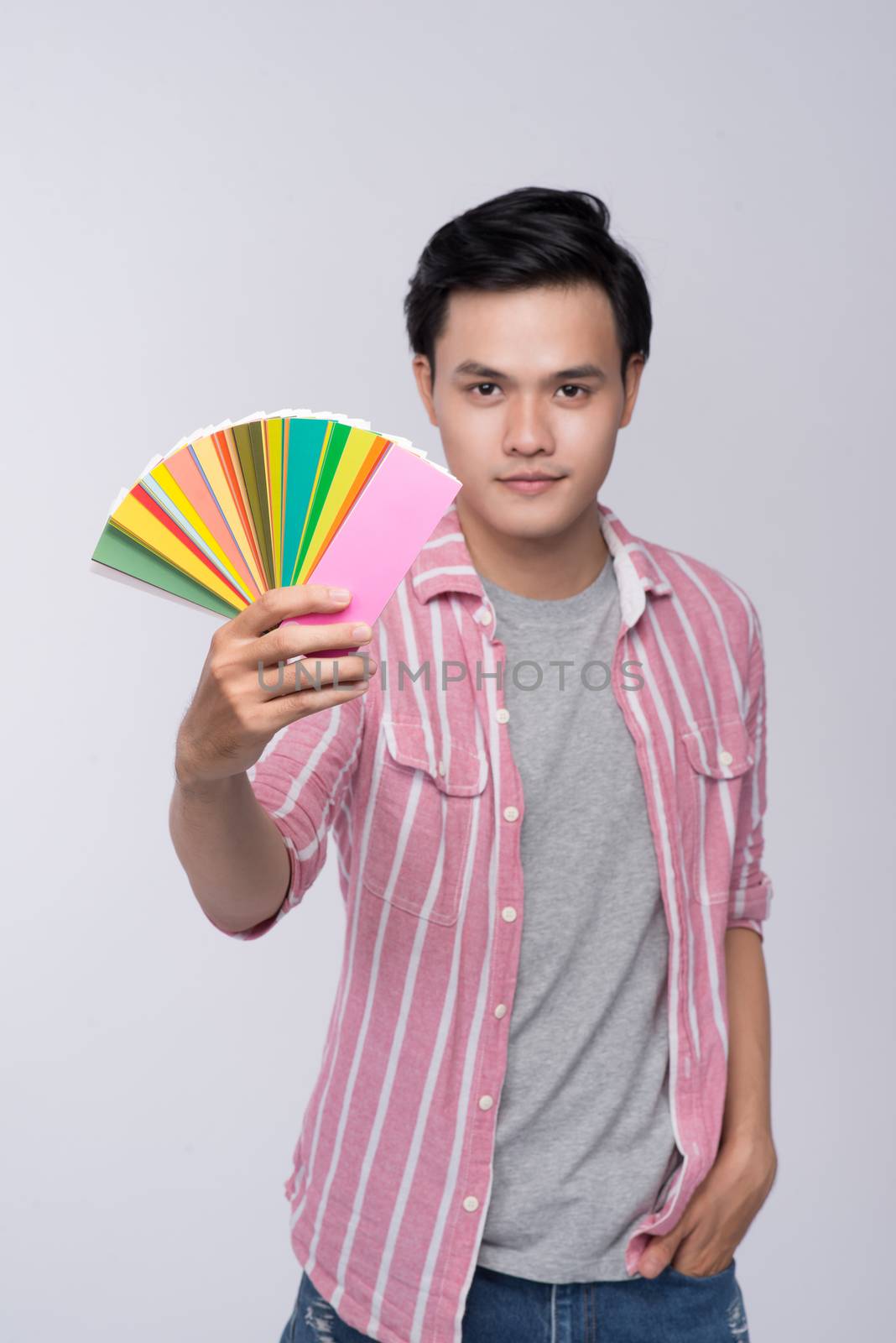 Young asian graphic designer holding color palette by makidotvn