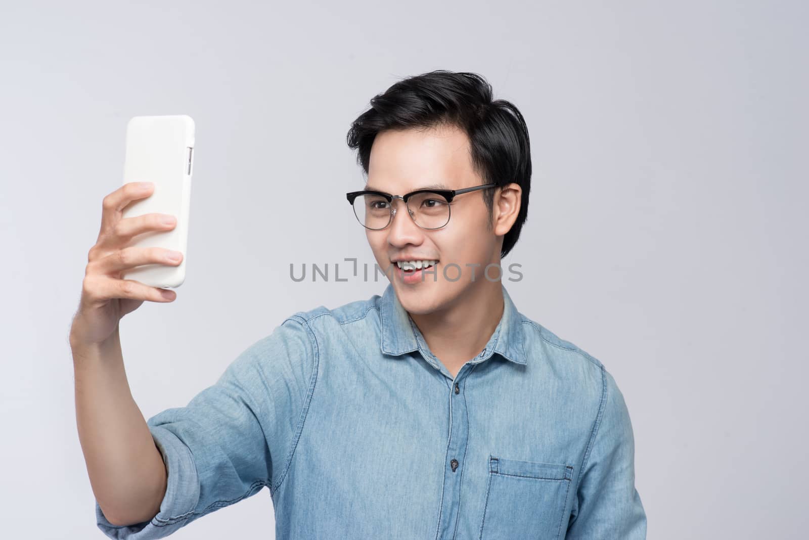 Smart casual asian man taking selfie photo by smartphone
