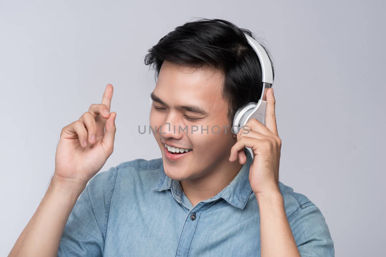 Smart casual asian man with headphone in studio background by makidotvn