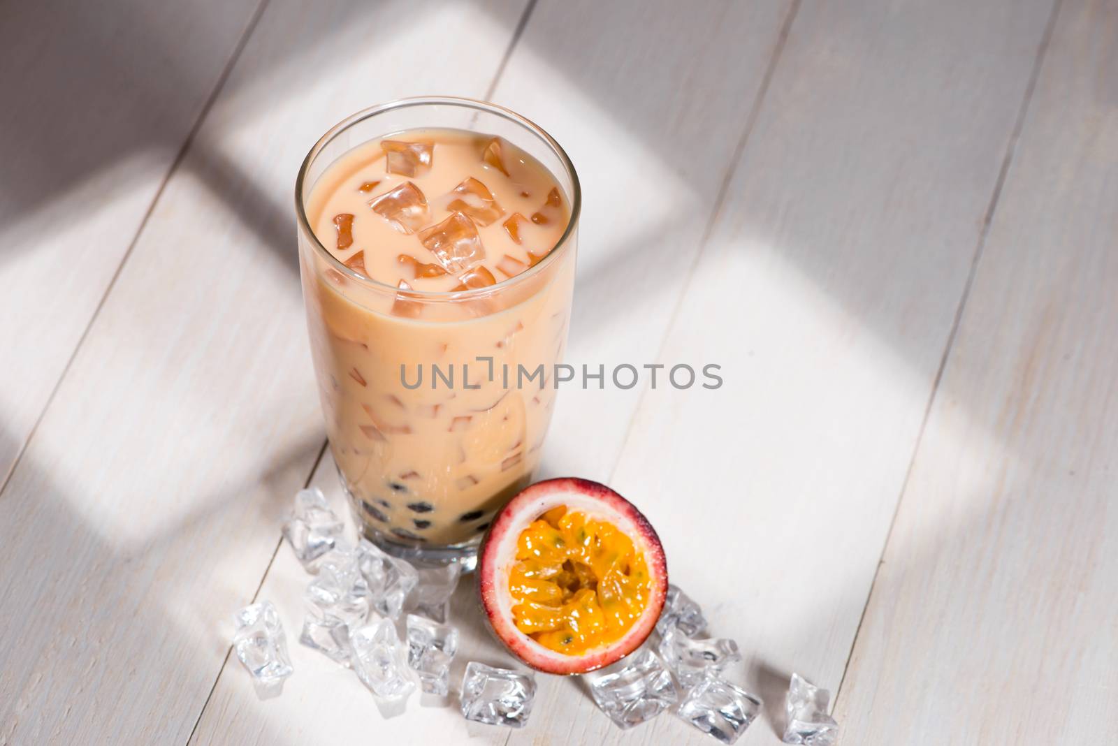 Bubble tea. Homemade Passion Fruit Milk Tea with Pearls on wooden table.