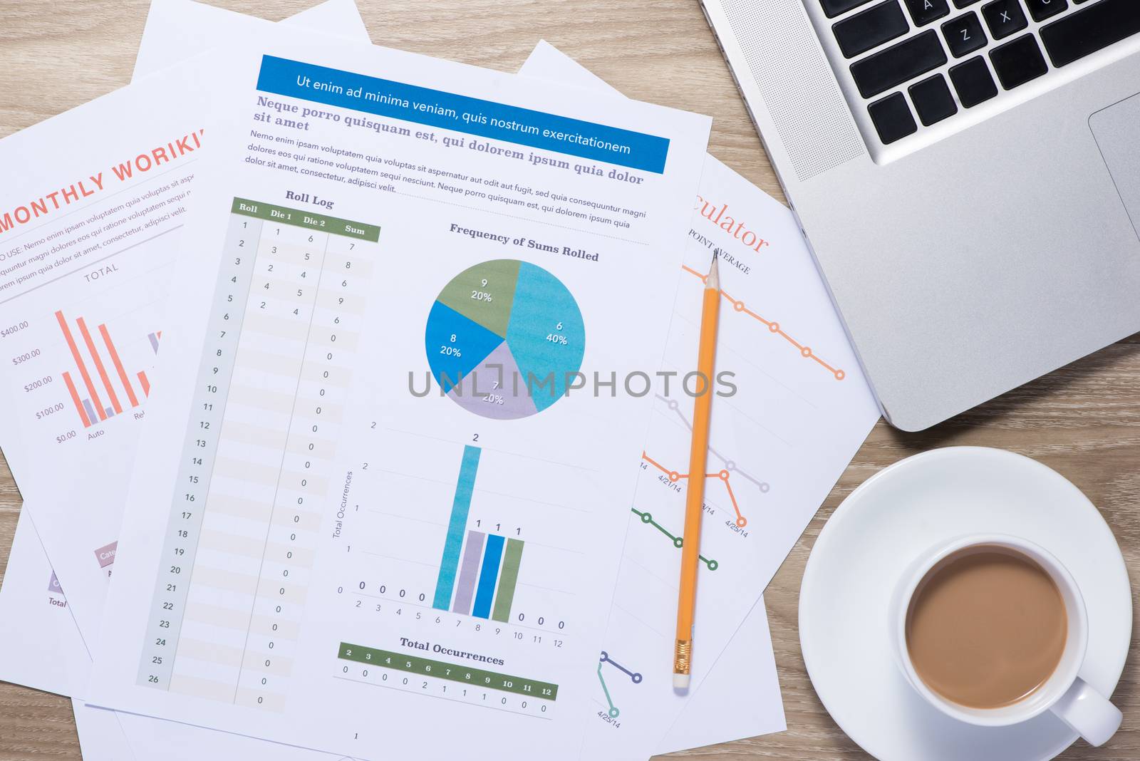 Business graphs and charts on a wooden desk with laptop, coffee mug and pen