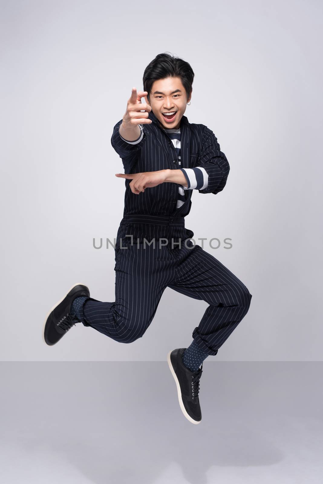 Active young handsome asian man. Cool fashion male model jumping