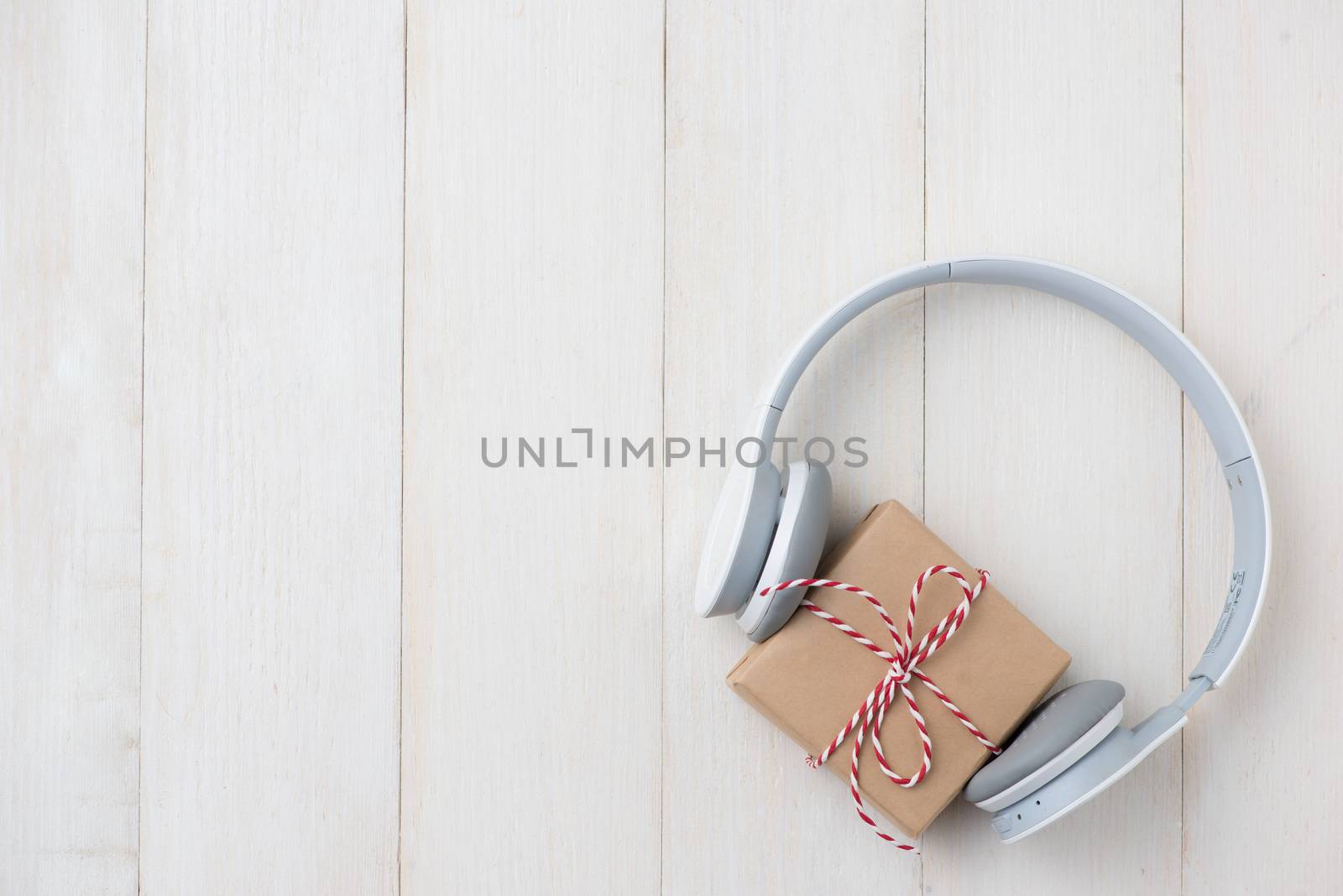 Top view of gift box with headphones on wooden table by makidotvn