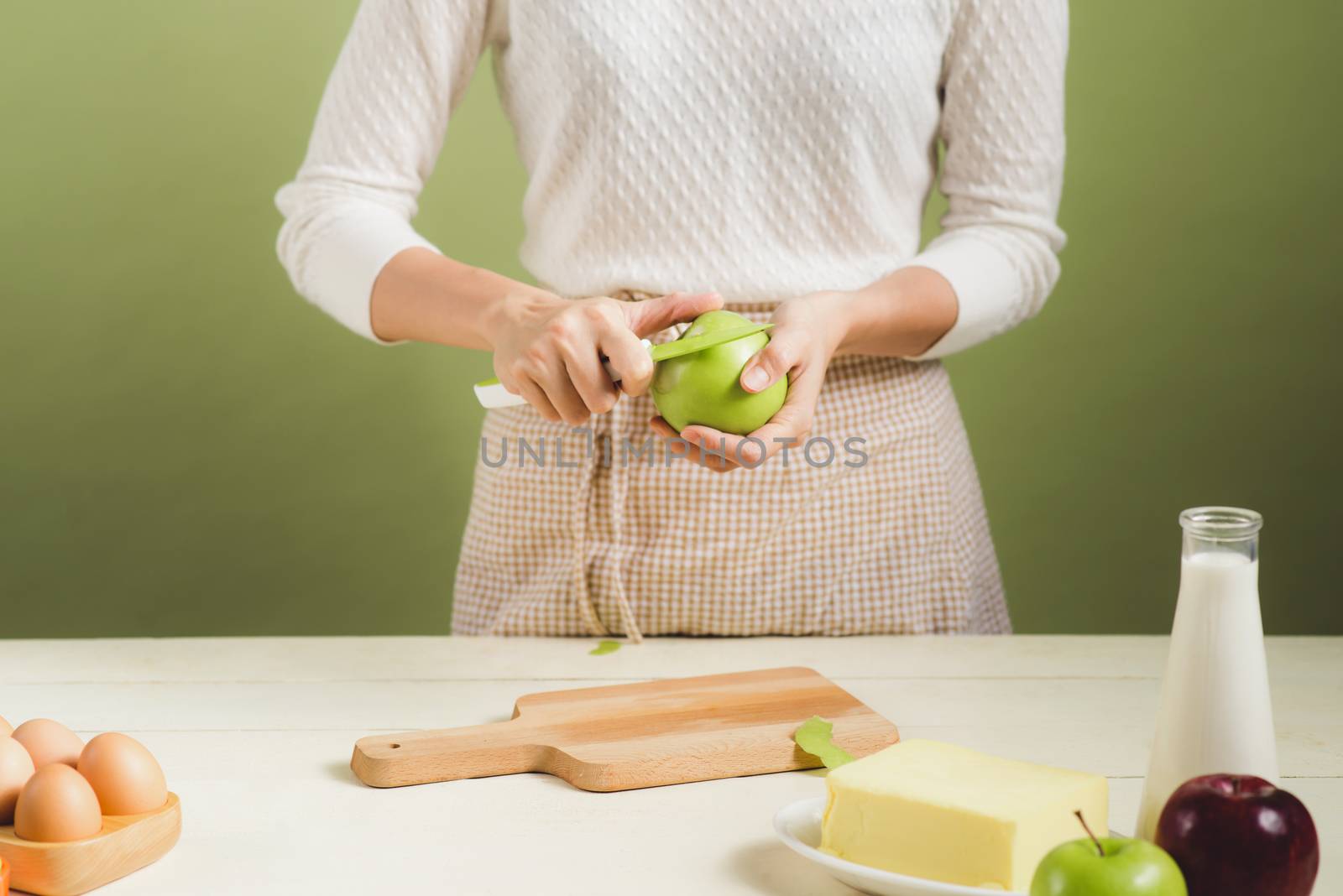 House wife wearing apron making. Steps of making cooking apple cake. Cutting green apple.