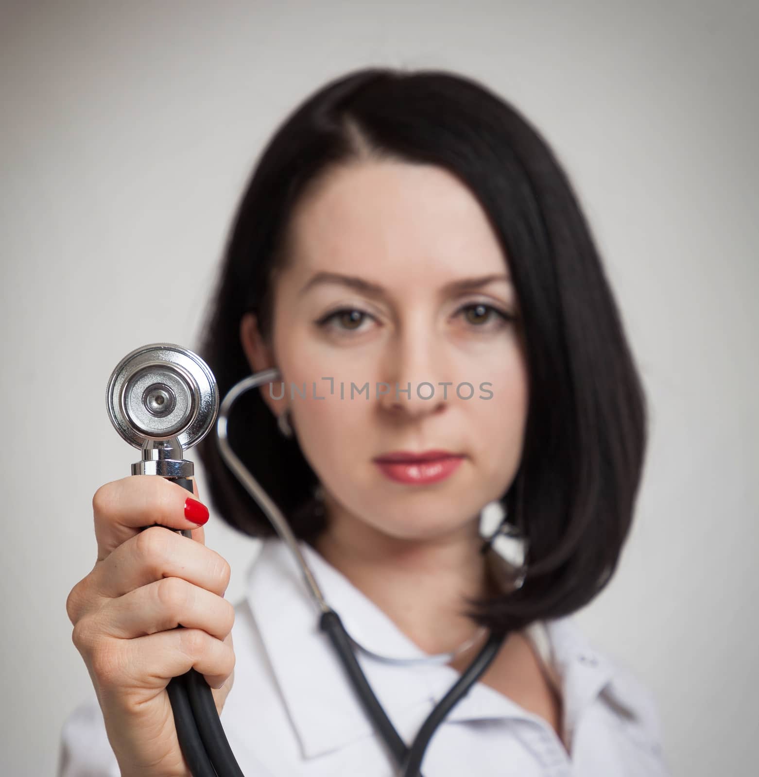 the beautiful woman the doctor with a stethoscope on a white background