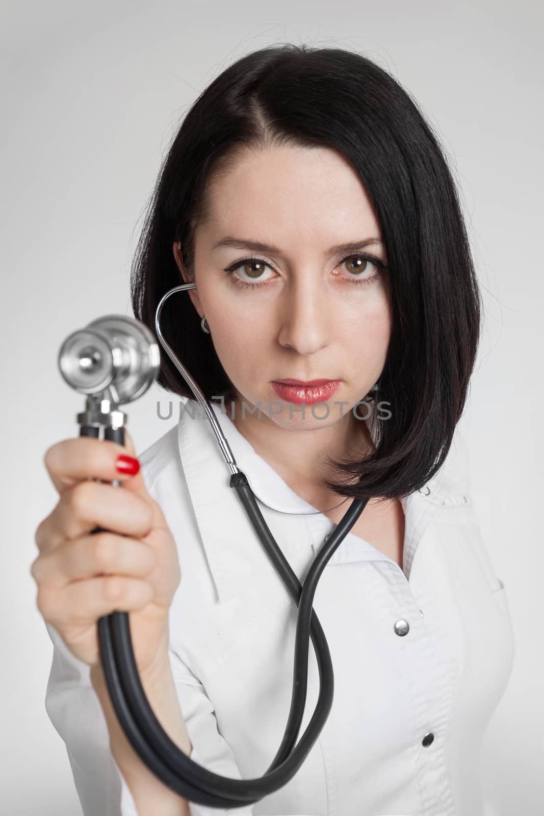 the beautiful woman the doctor with a stethoscope on a white background