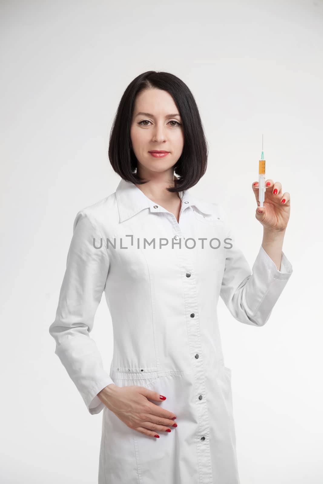 the beautiful woman the doctor with the syringe on a white background