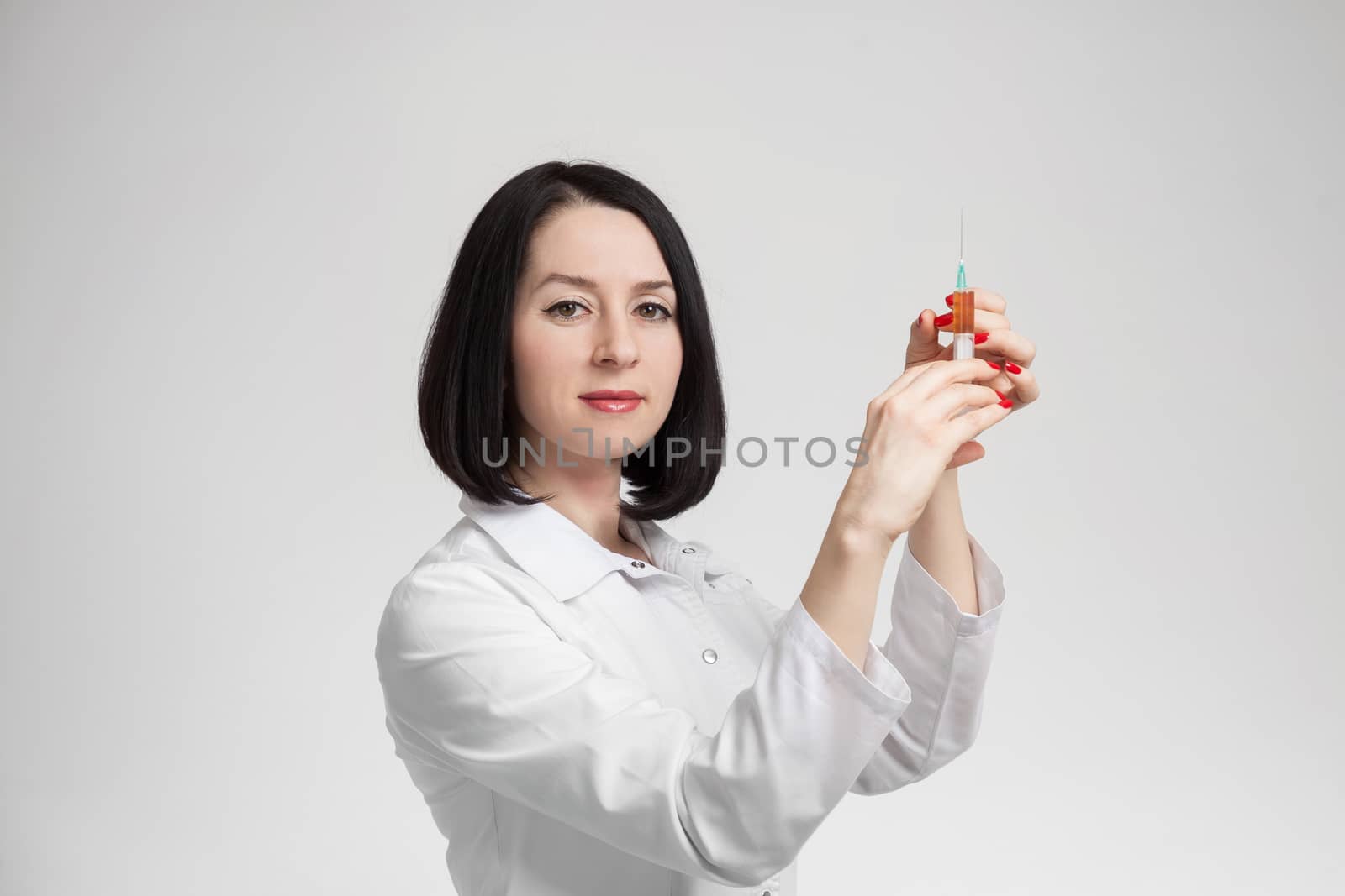 the beautiful woman the doctor with the syringe on a white background