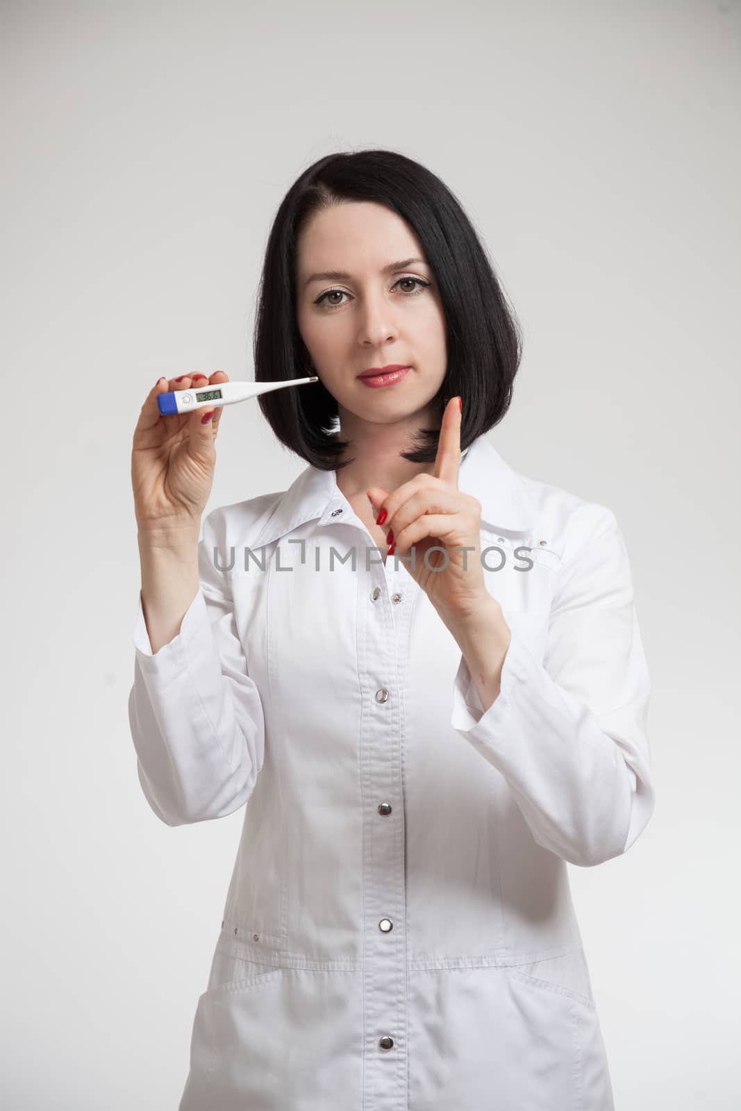 the beautiful woman the doctor with a thermometer on a white background