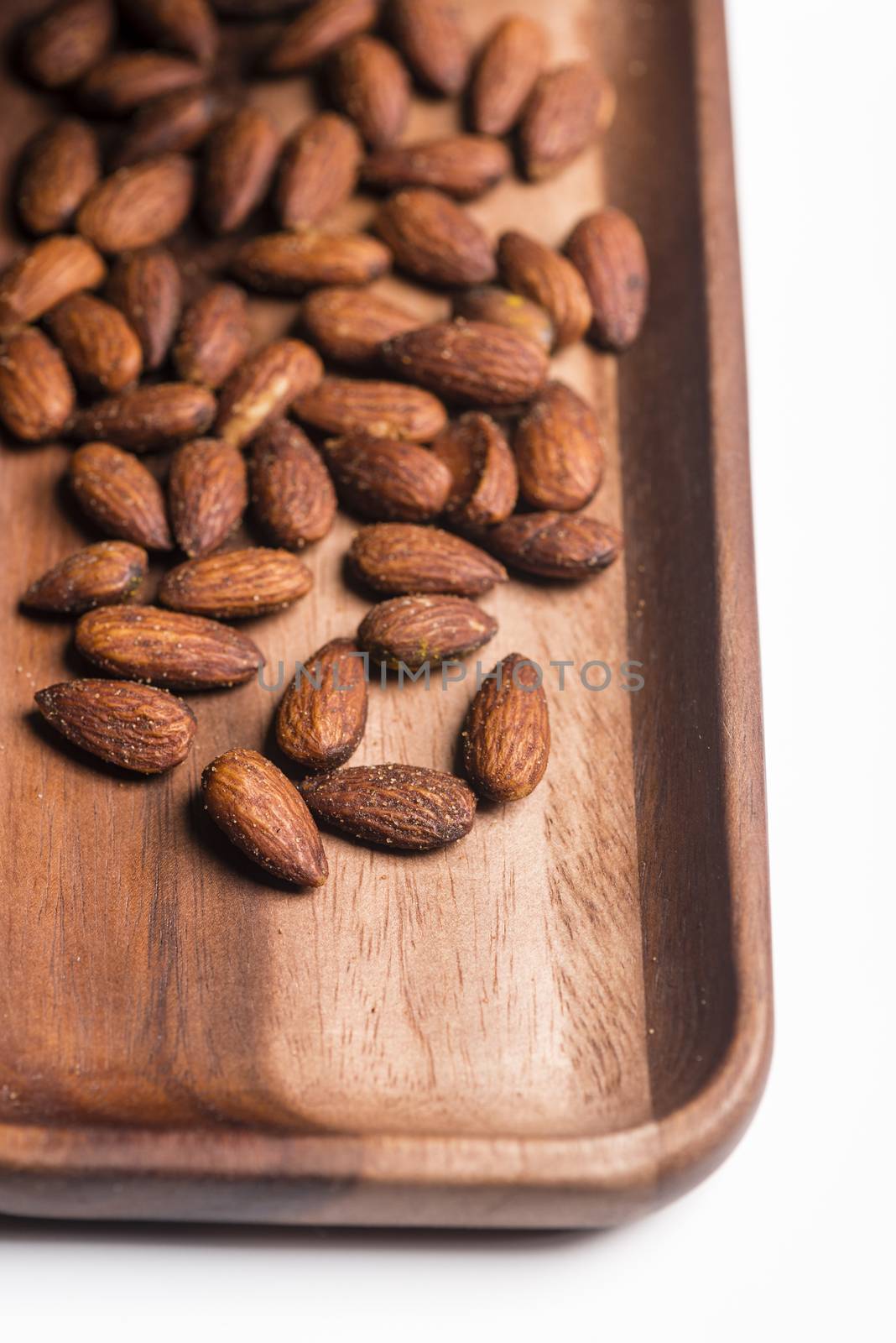Toasted almonds  in a wood sish over a black board.