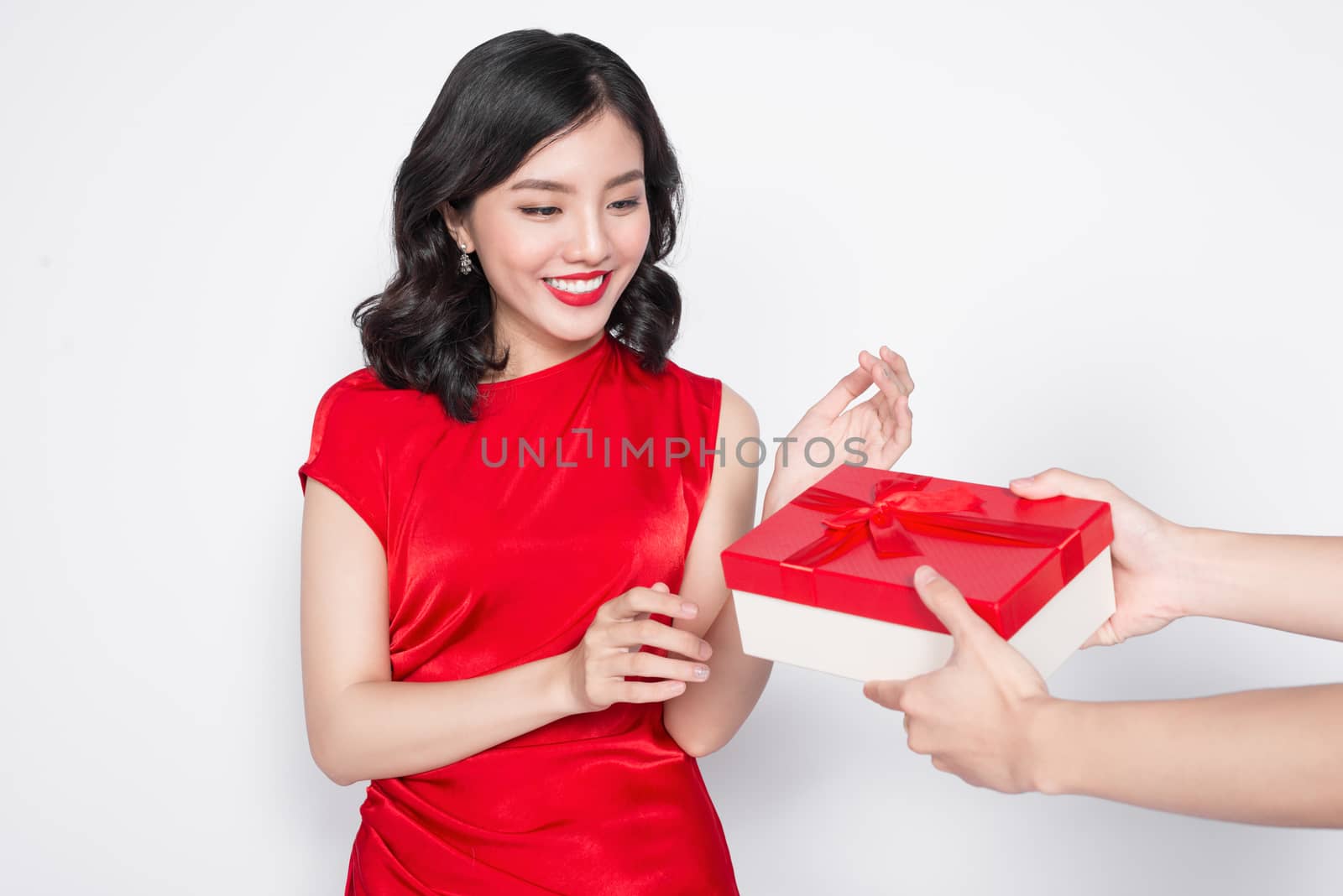 Beautiful happy asian woman in red dress receiving gift box by makidotvn