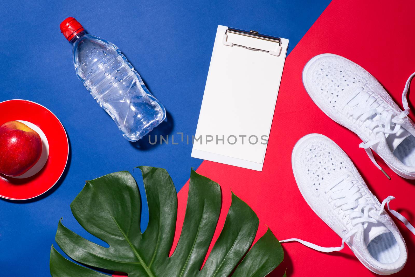 Sport concept. Fitness equipment. Sneakers, water, apple, dumbbe by makidotvn