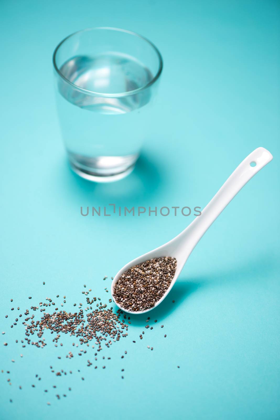 Glass of water and healthy chia seeds in a spoon. Text space. by makidotvn