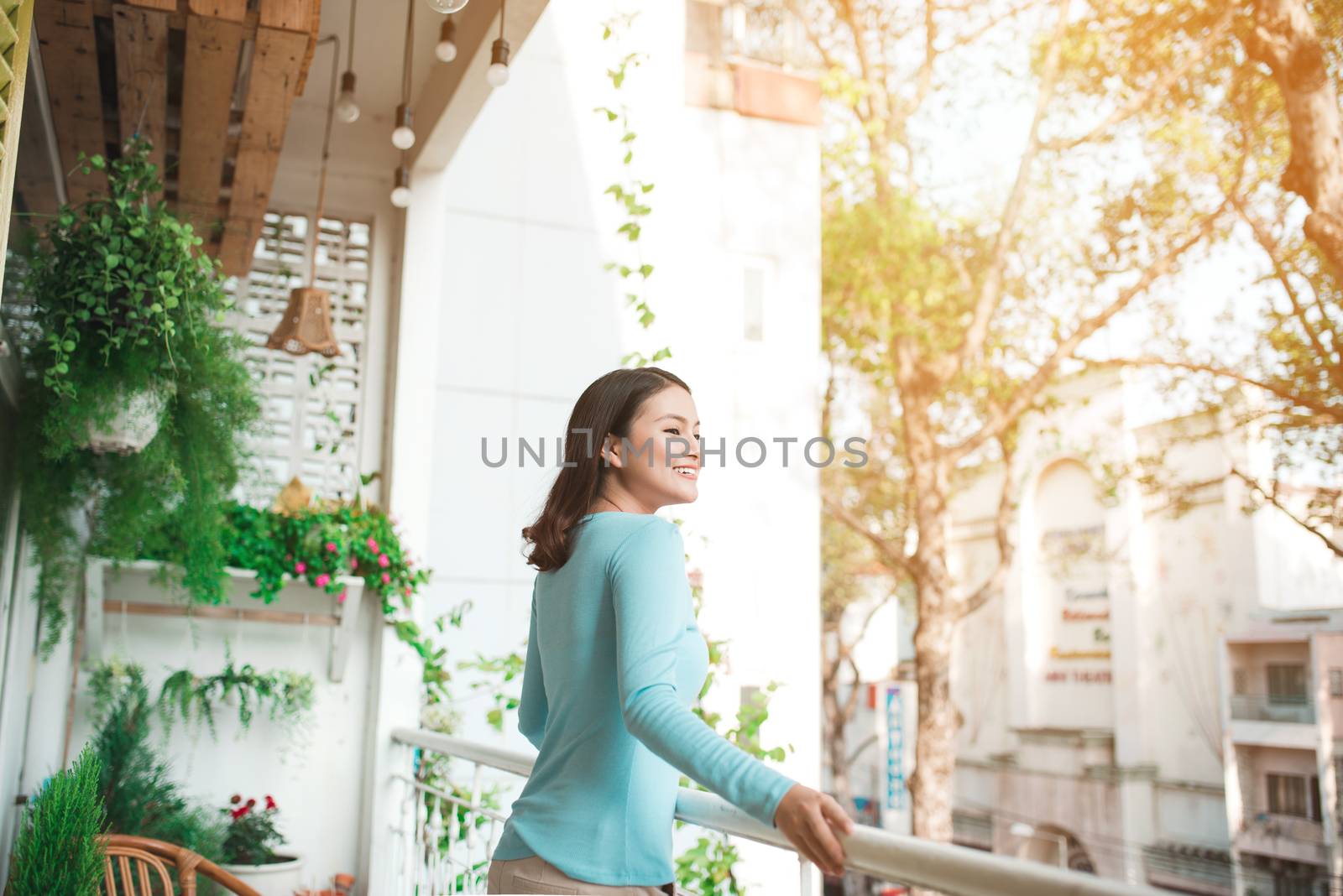 Beautiful asian girl enjoying the freshness on balcony