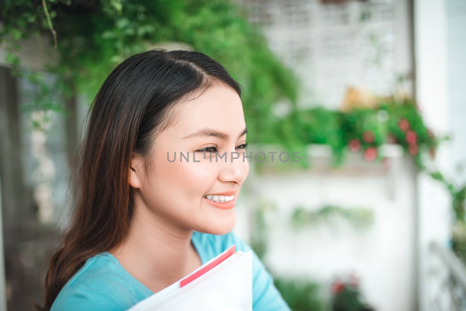 Asian smiling woman reading novel book at home.