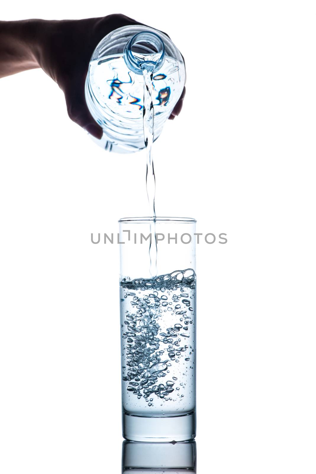 Drinking water is poured into a glass from bottle by makidotvn