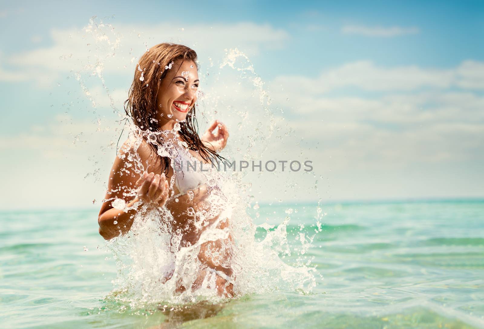Beautiful young woman having fun and enjoying in the sea, on the beach. 