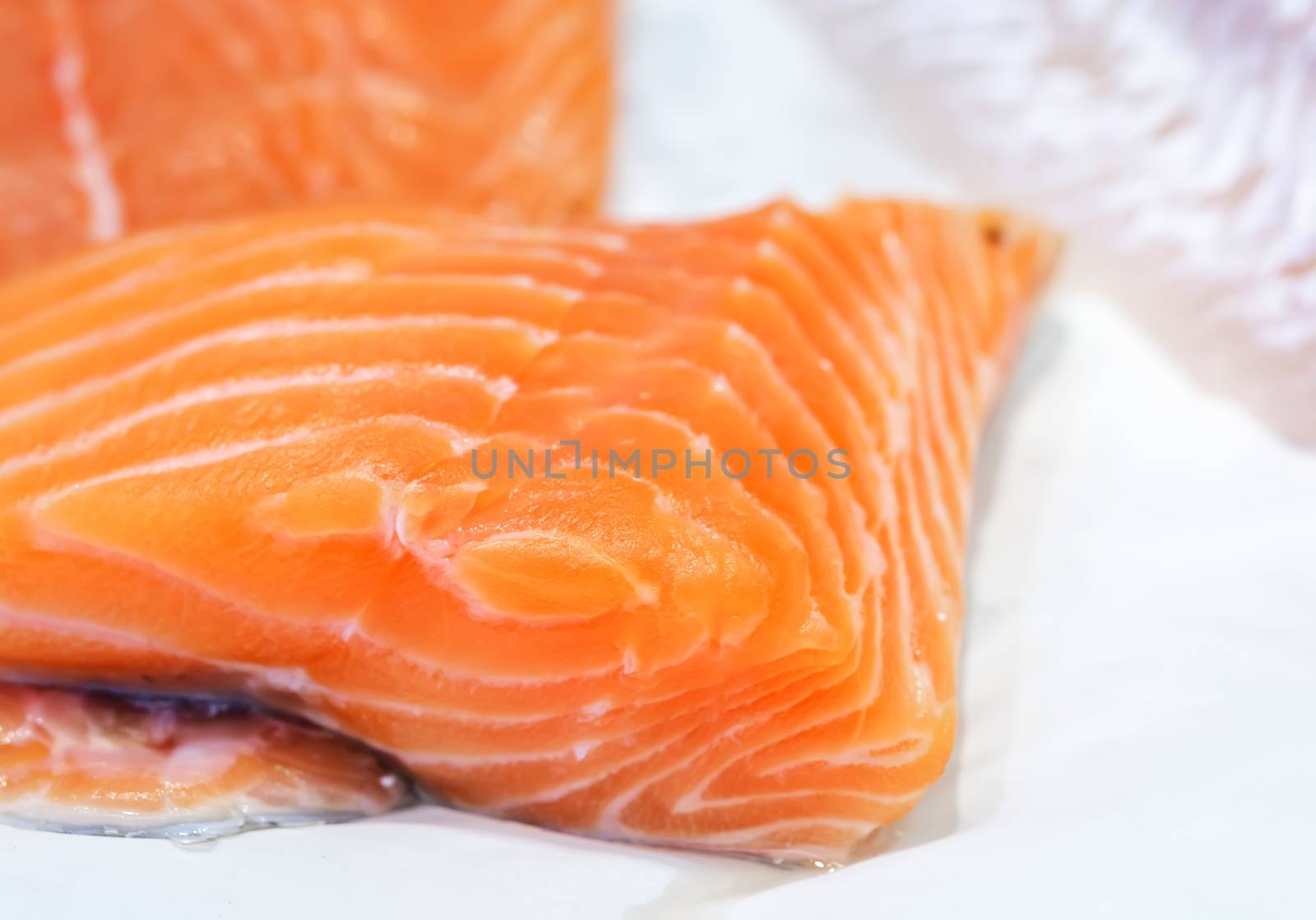 fresh uncooked salmon fillet on showcase of seafood market.