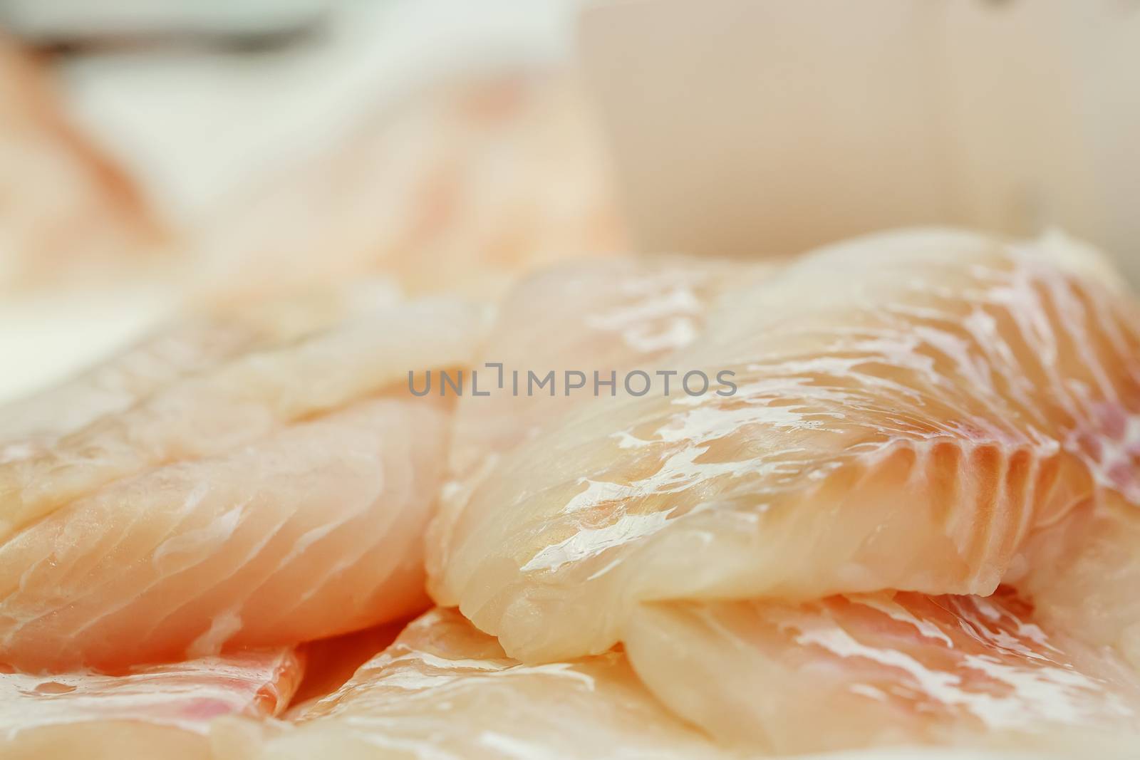 fresh Fish fillets on showcase of seafood market by pixinoo