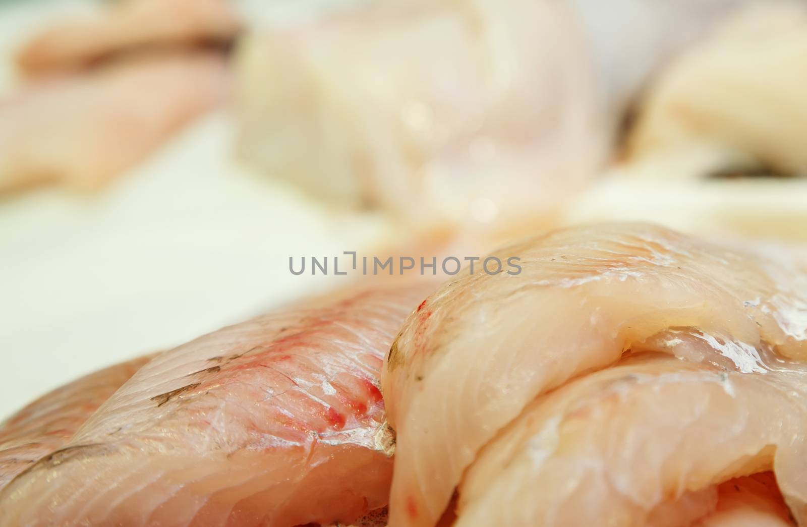 fresh Fish fillets on showcase of seafood market by pixinoo