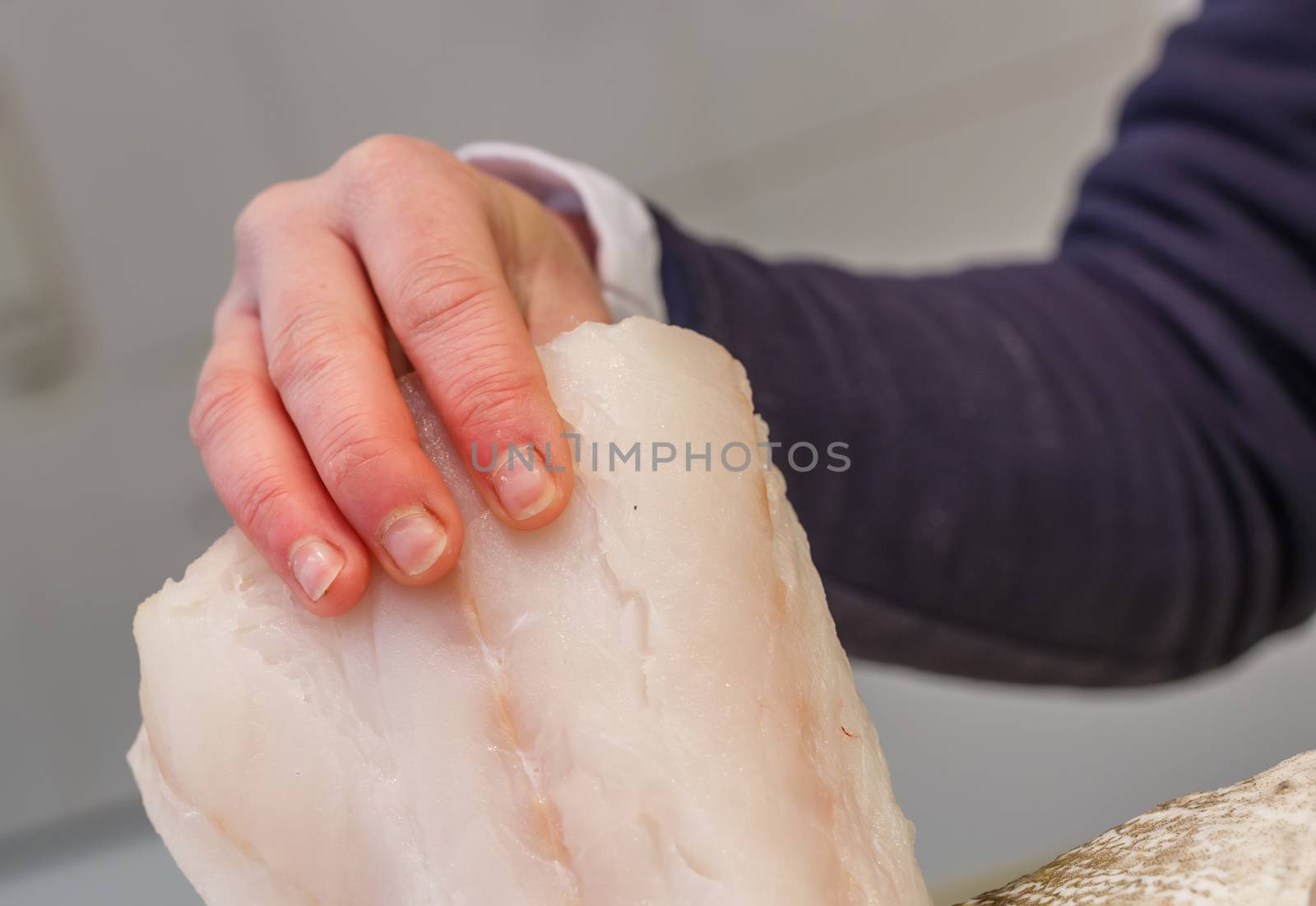 Fishmonger holding a piece of fresh fish in a market