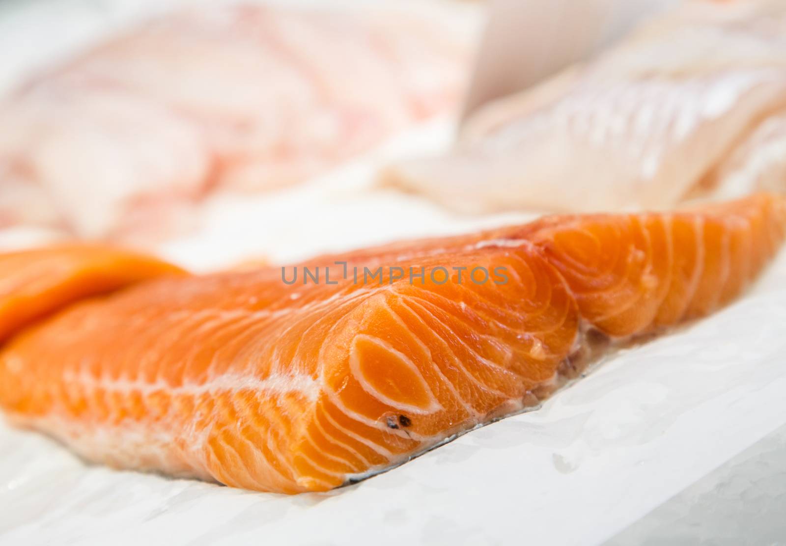 Fillet fresh uncooked seafood salmon on showcase of seafood mark by pixinoo