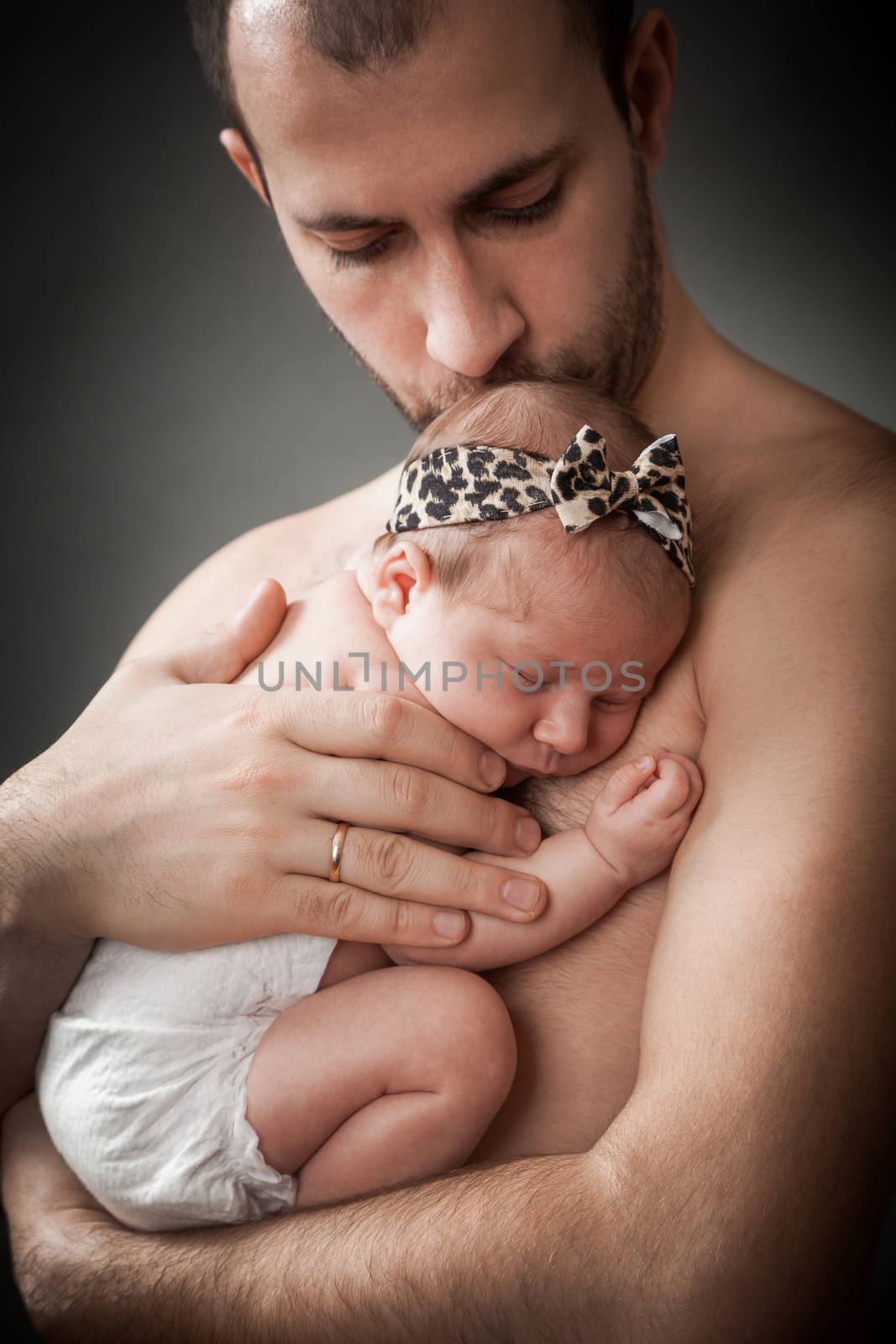 the father holds on hands of the newborn child