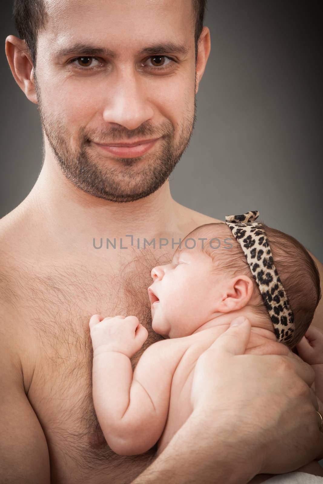 the father holds on hands of the newborn child