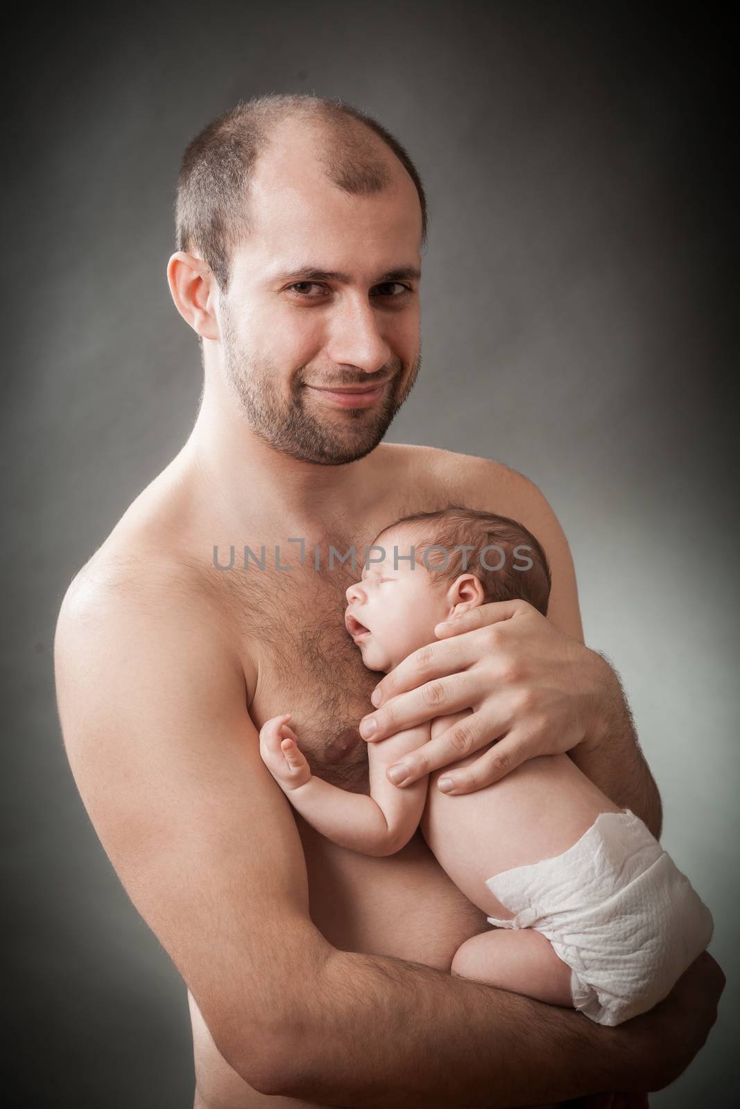 the father holds on hands of the newborn child