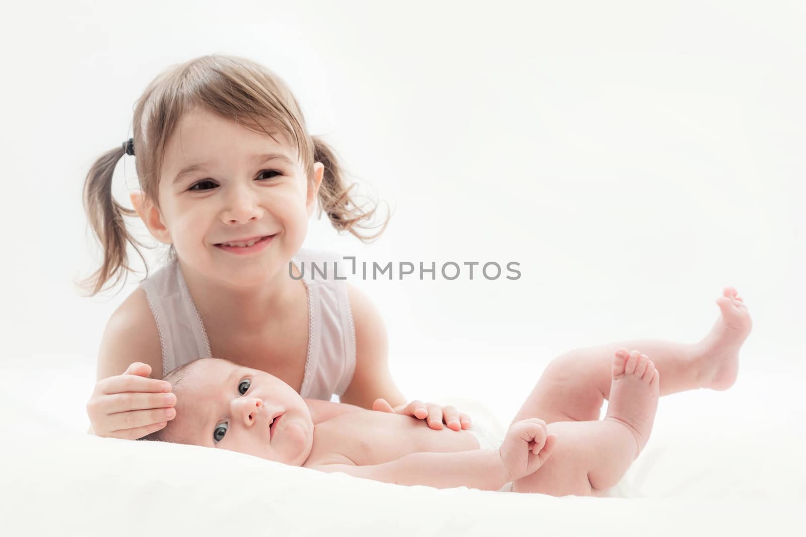 elder sister and the younger newborn child on a white background