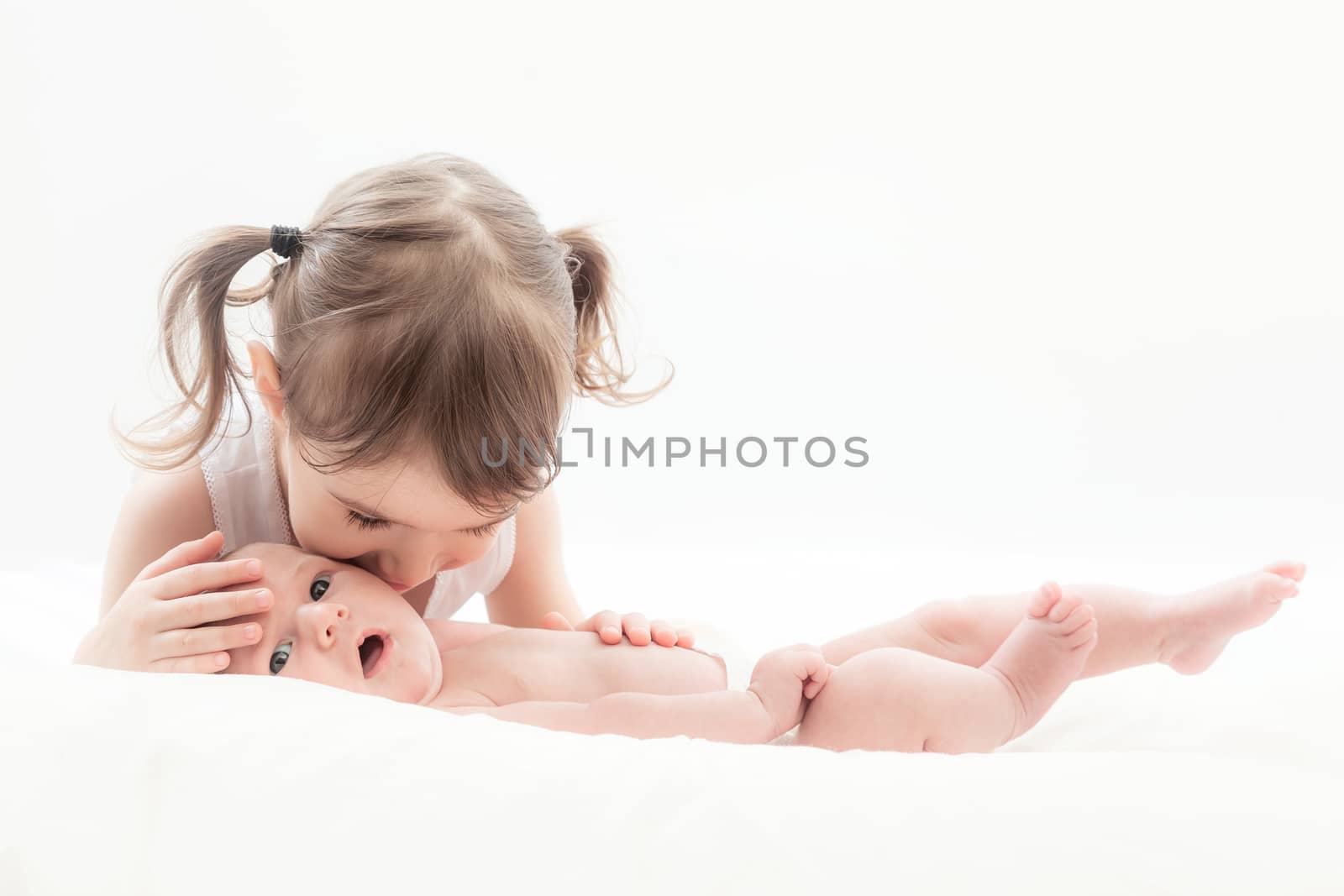 elder sister and the younger newborn child on a white background