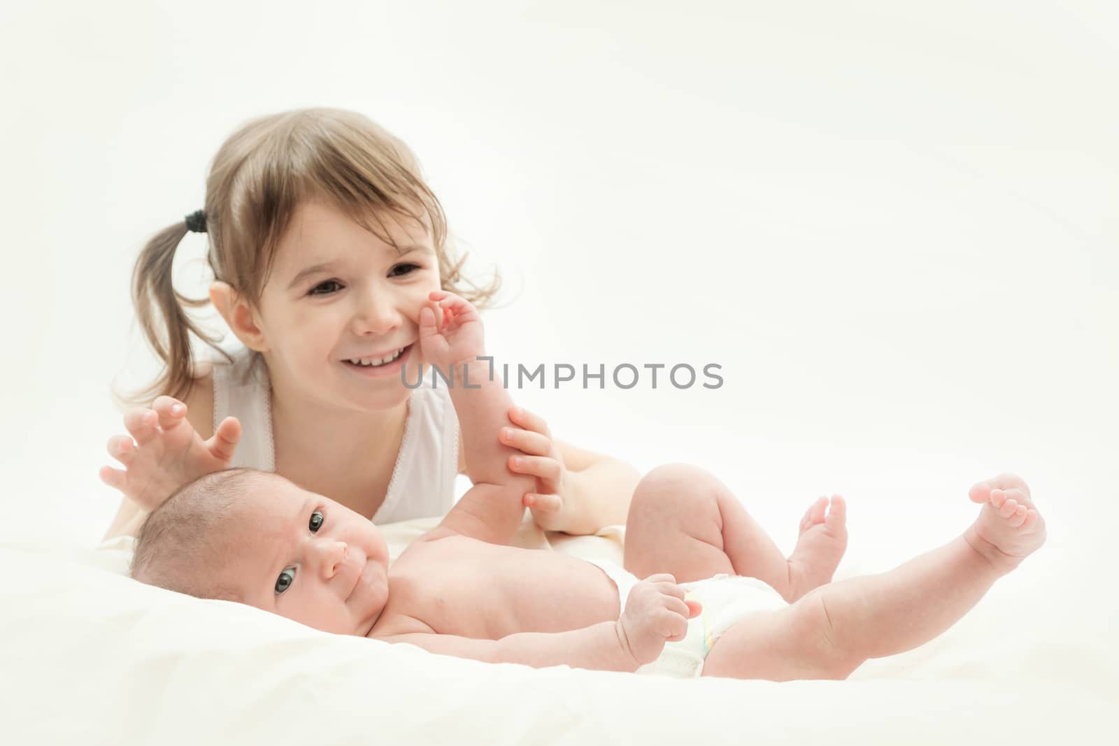 elder sister and the younger newborn child on a white background