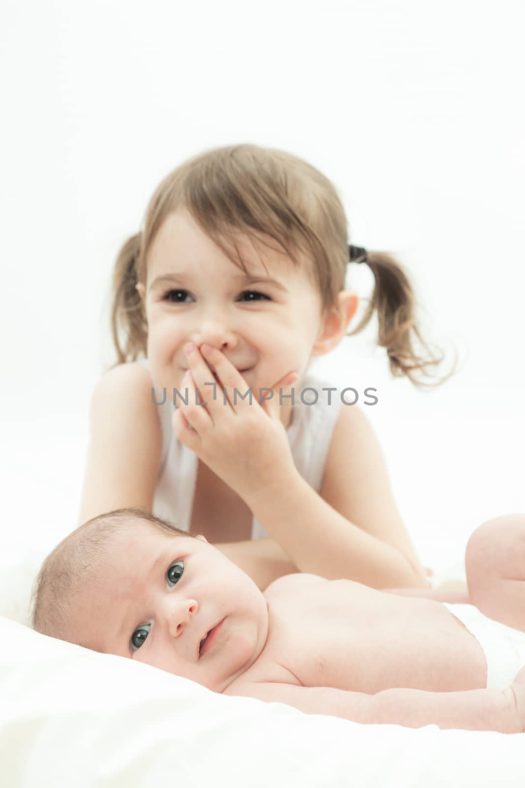 elder sister and the younger newborn child on a white background