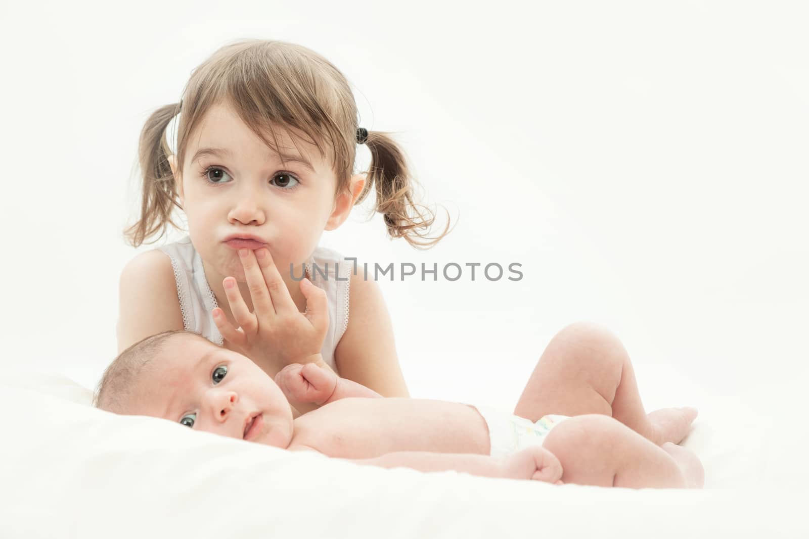 elder sister and the younger newborn child on a white background