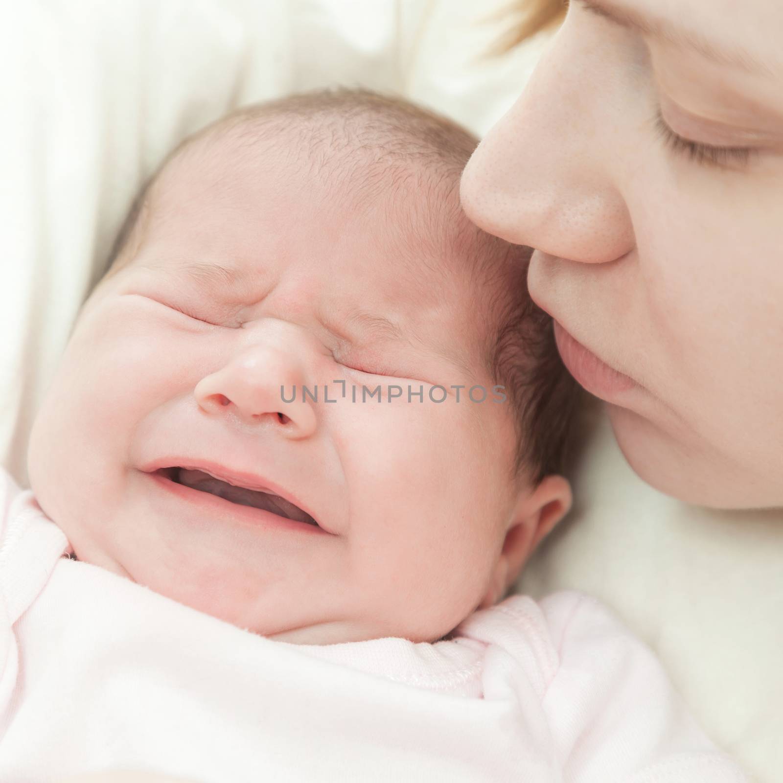 mother kisses the small newborn child a fragment