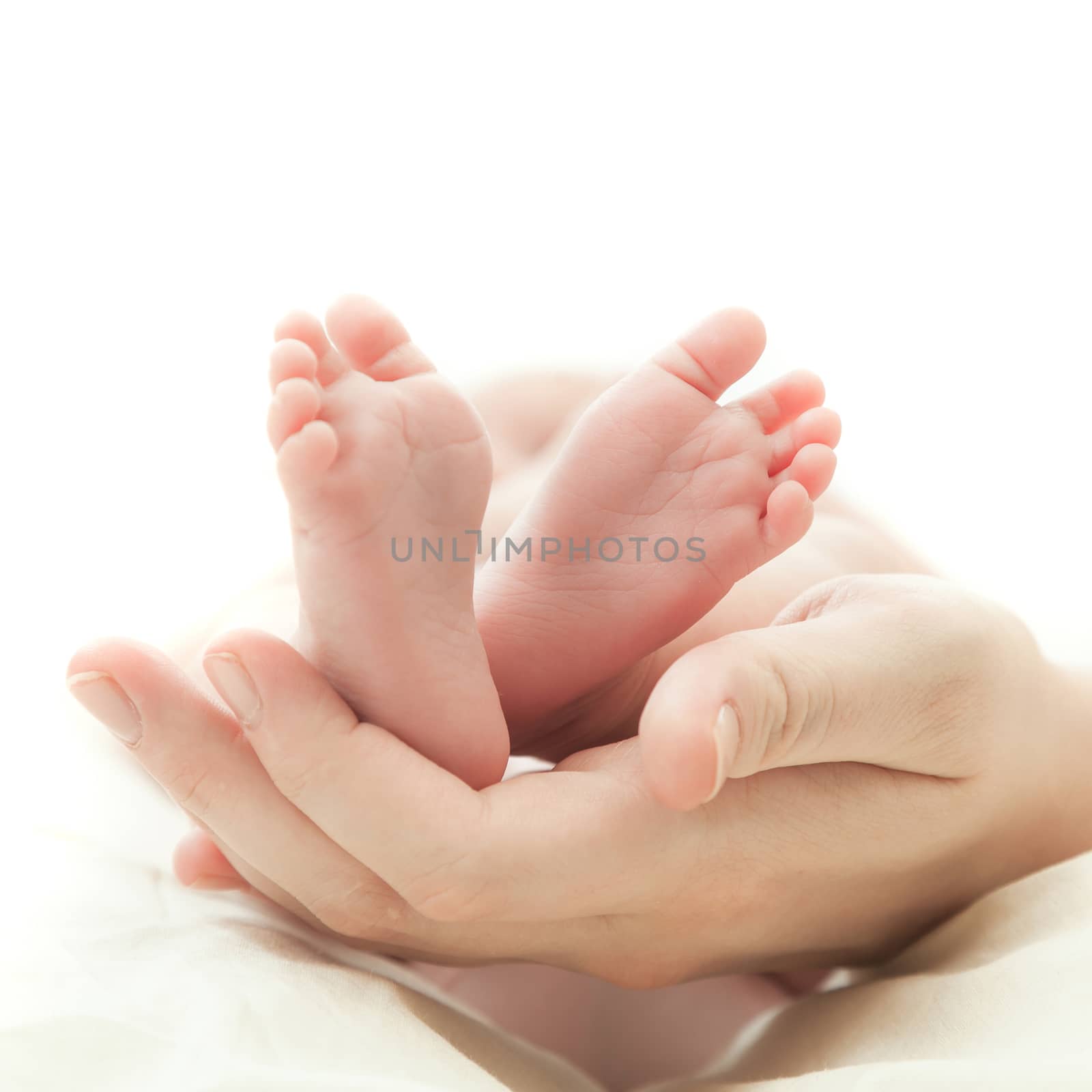 the mother's hand holds legs of the newborn child