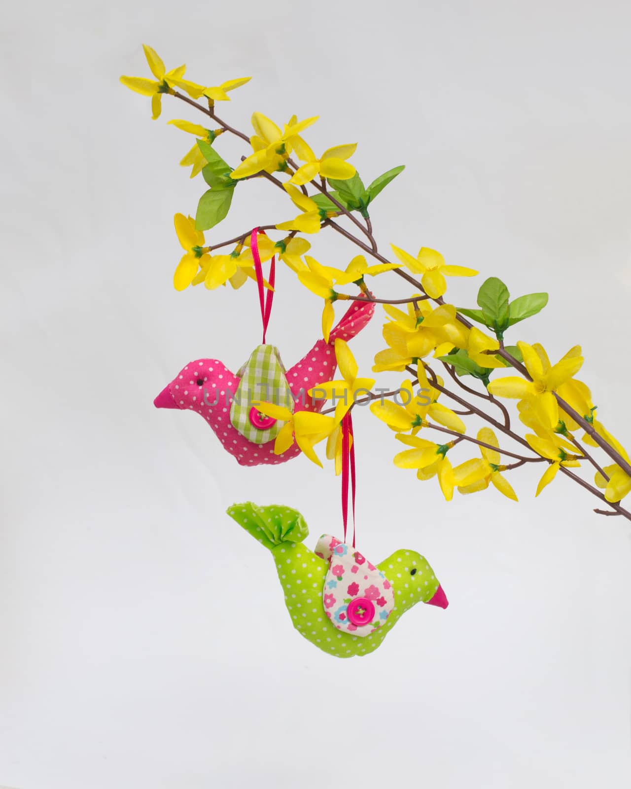 Two birds of fabric (handwork) on an artificial forsythia branch