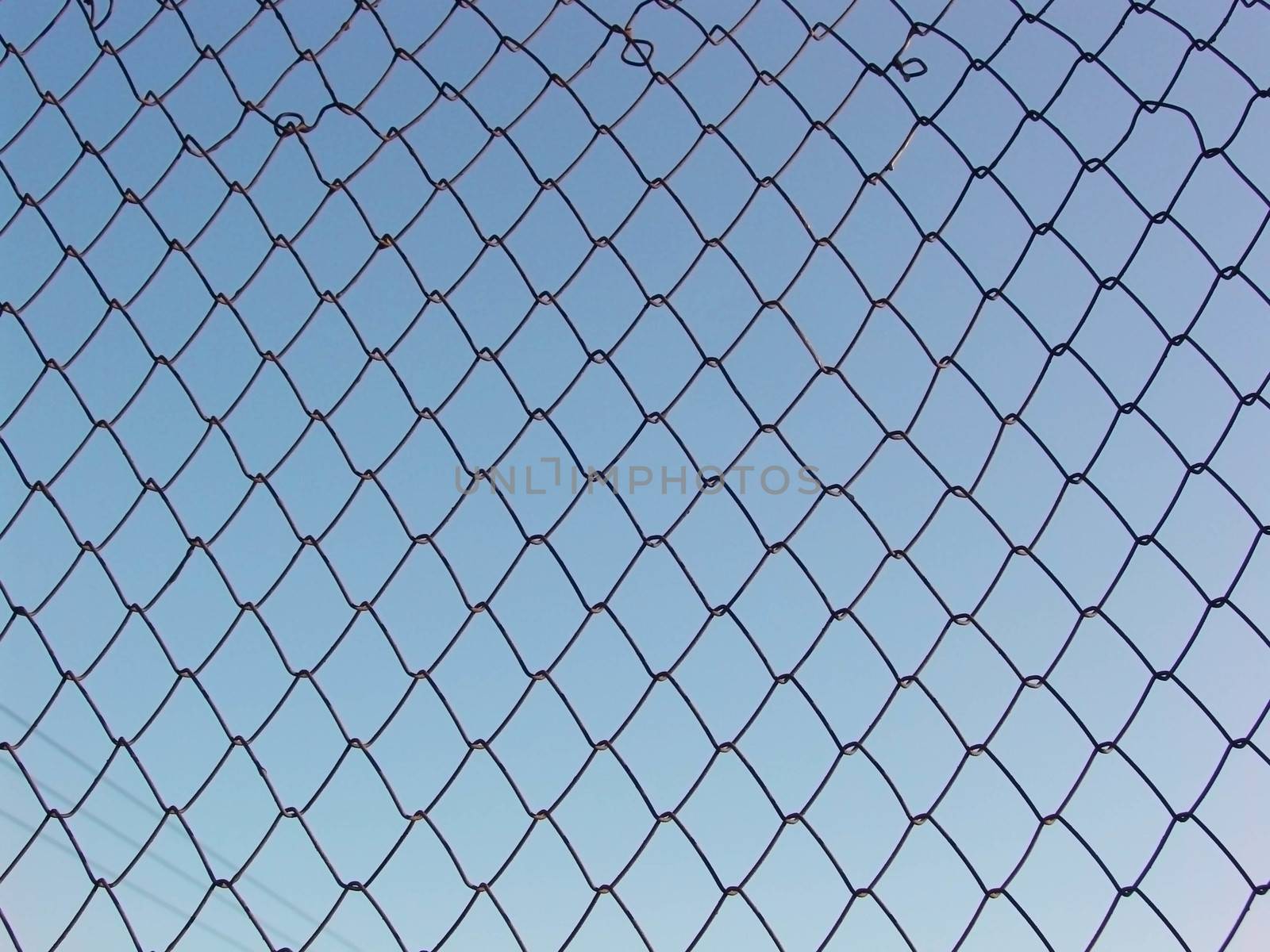 Metal wire fence with blue sky white cloud background by elena_vz