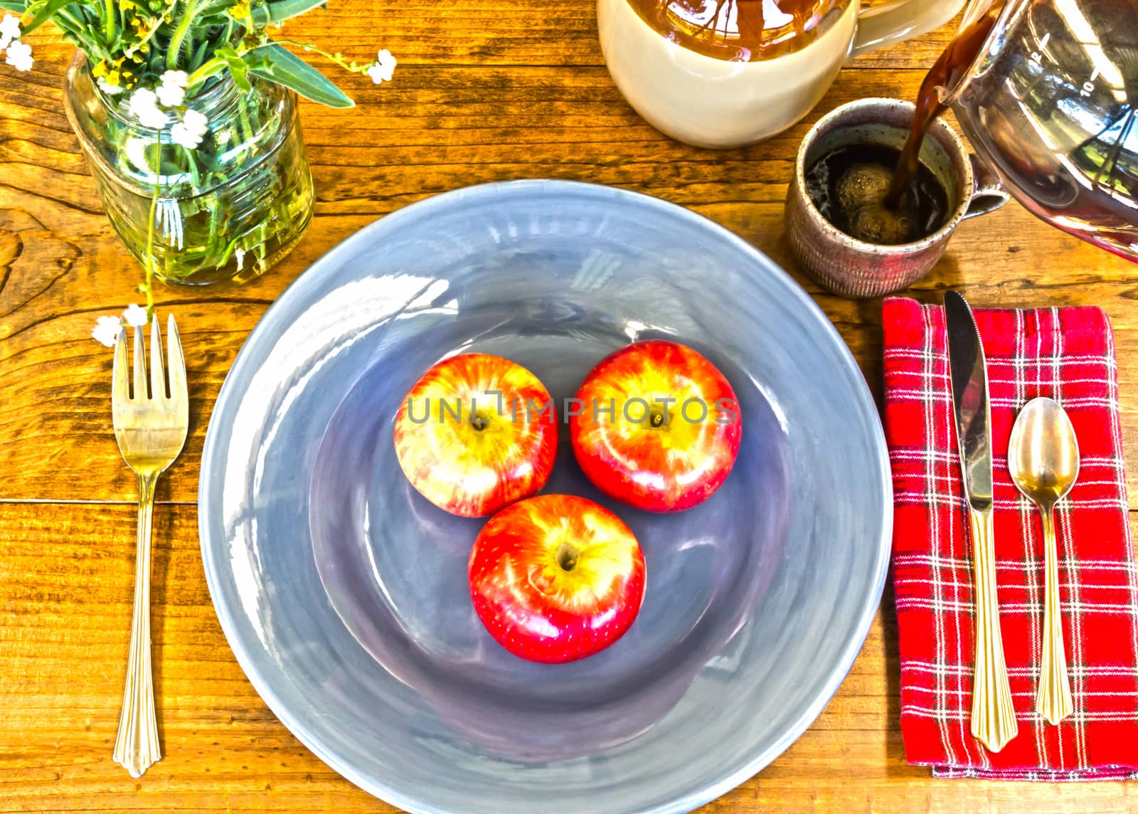 Place Setting With Red Apples, Flowers and Crockery on Wooden Table With Knots and Brewed Coffee Poured in Cup