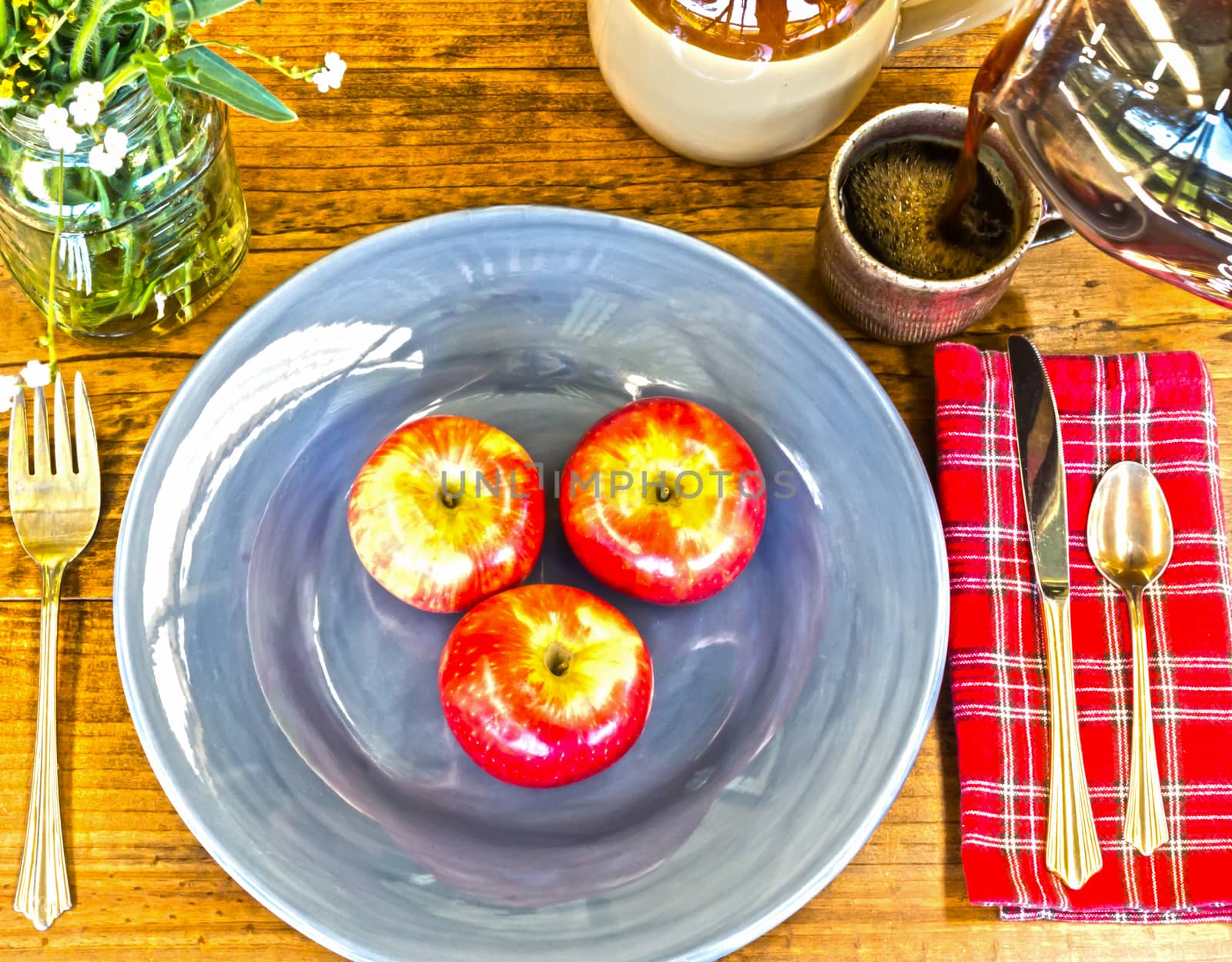 Place Setting With Red Apples, Flowers and Crockery on Wooden Table With Knots and Brewed Coffee Poured in Cup