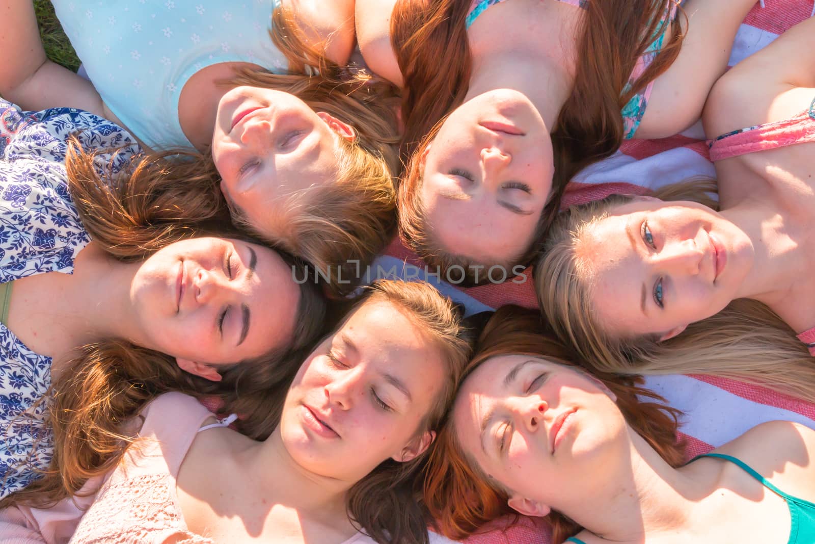 Girls Laying on the Ground Looking up, Some With Eyes Closed by gregorydean