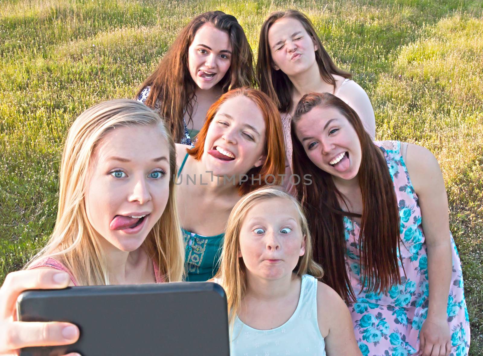 Group of Cute Young Girls  Taking a Selfie with Green Grass in the Background