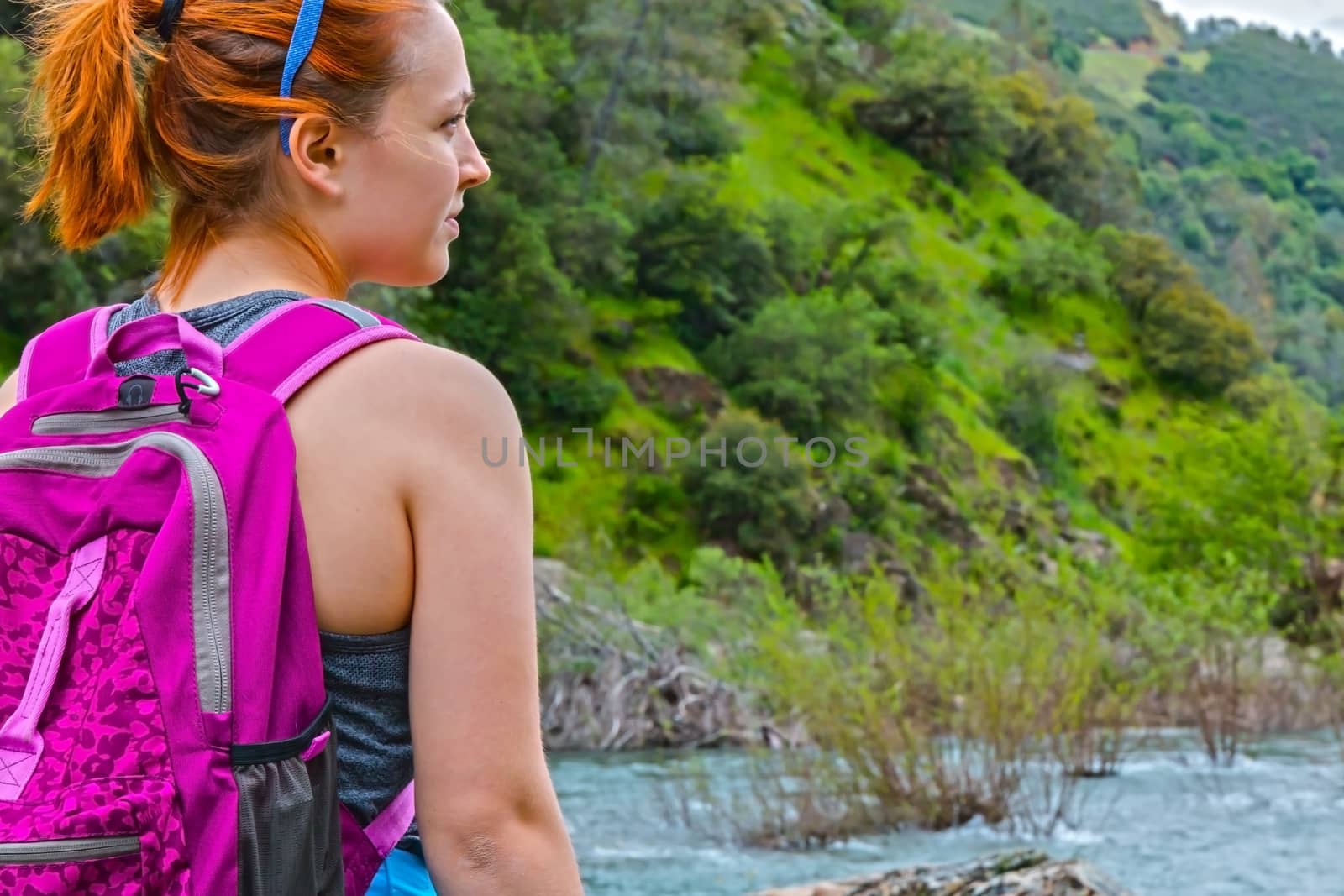 Girl Standing on Rocks Near Fast River by gregorydean