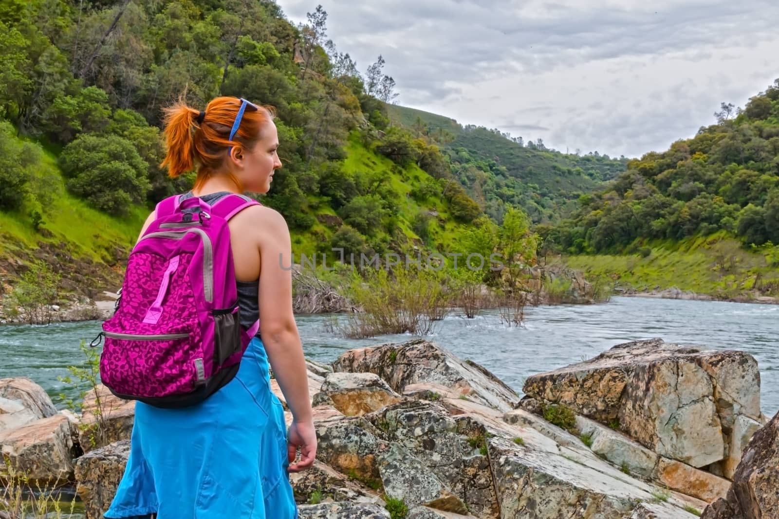 Girl Standing on Rocks Near Fast River by gregorydean