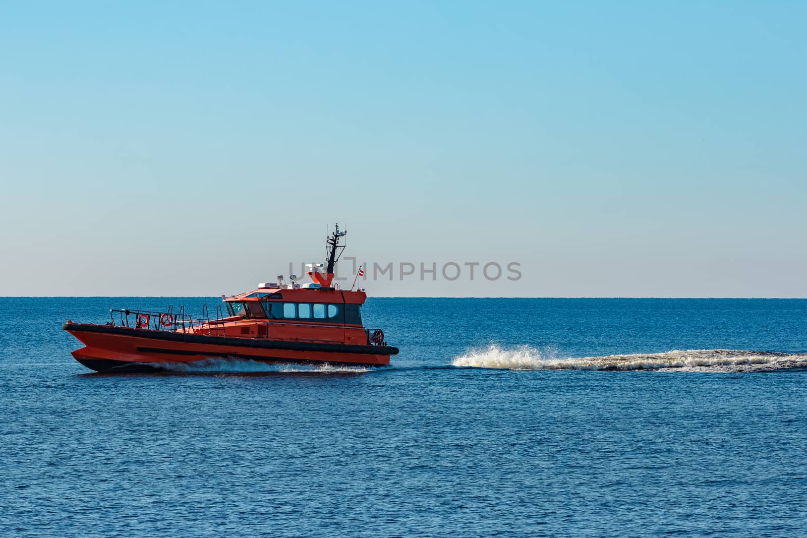 Orange pilot ship moving fast from Baltic sea
