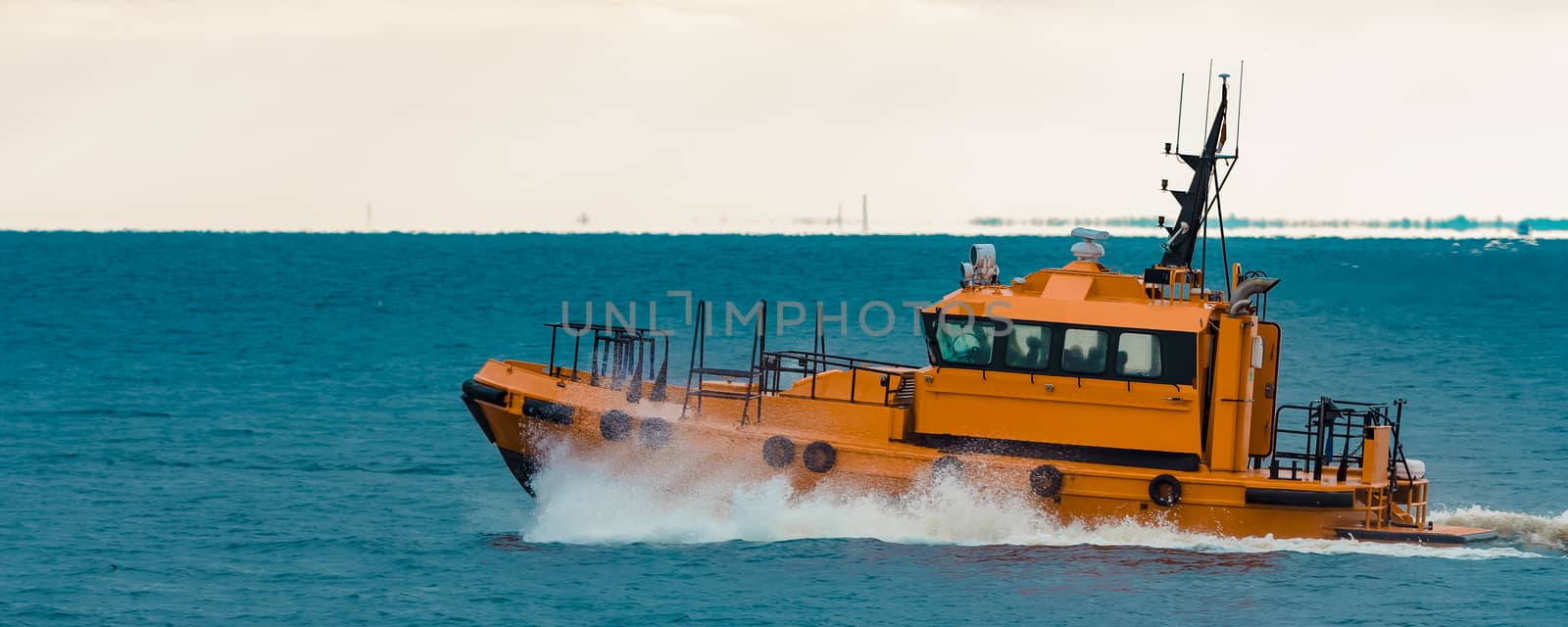 Orange pilot ship moving fast in Baltic sea. Europe