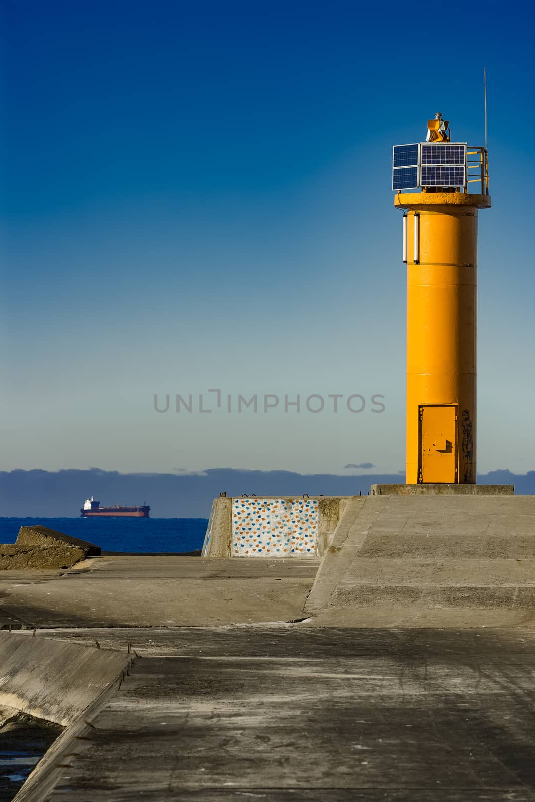 Yellow lighthouse on breakwater dam by sengnsp