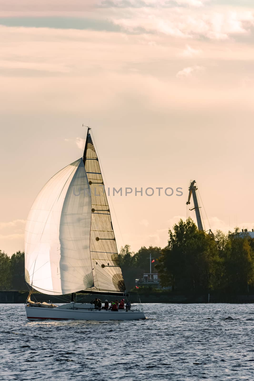 Sailboat moving on Daugava river in evening, Latvia