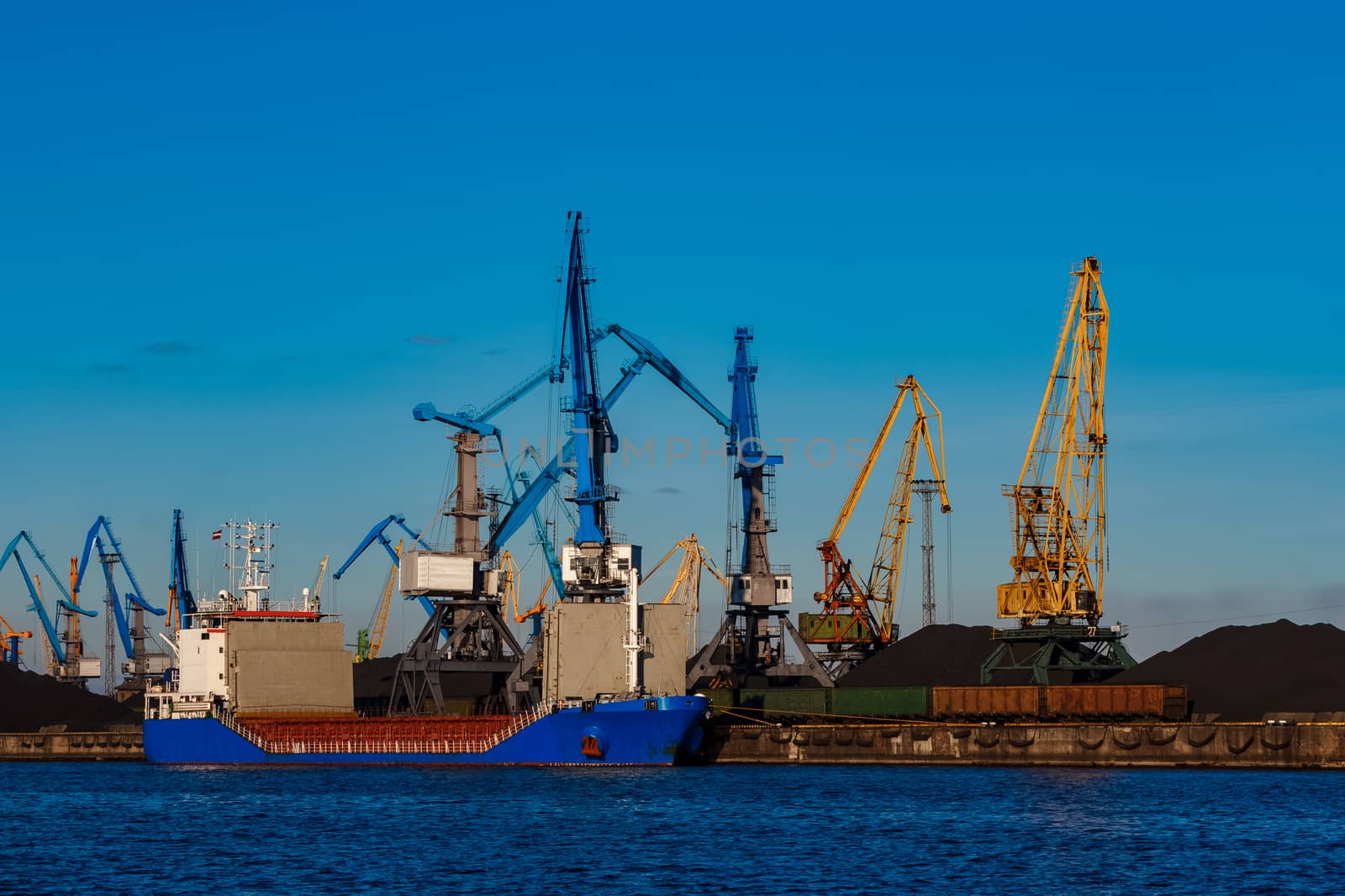 Blue cargo ship loading in the port of Riga, Europe